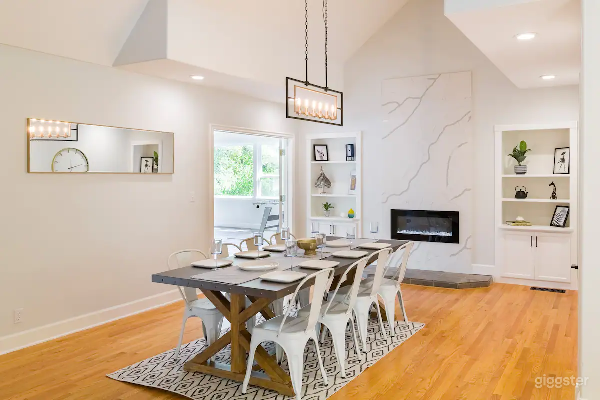 Formal dining room with farmhouse trestle table, cathedral ceiling, modern fireplace, and built in bookshelves