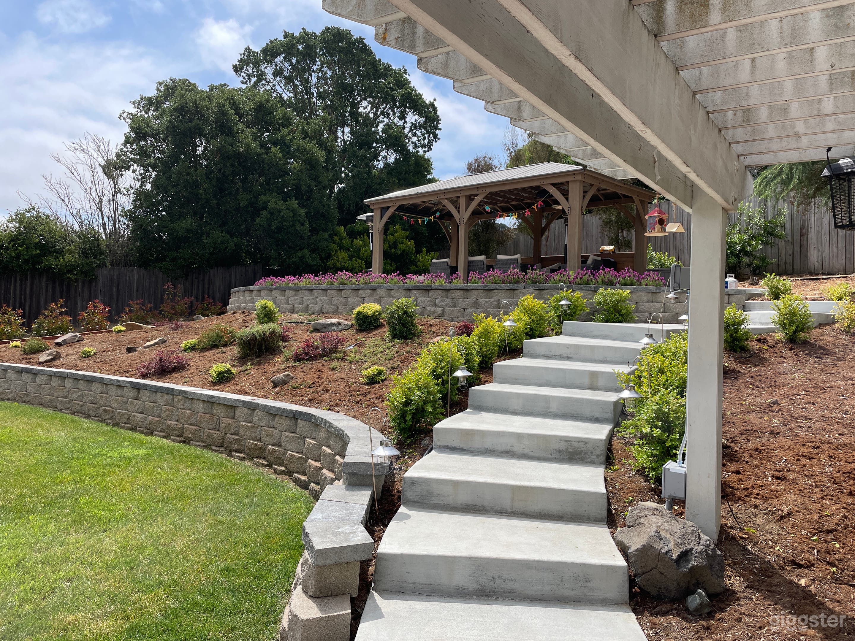 Outdoor Gazebo with architectural white washed concrete steps and beautiful retaining wall, lavender plants