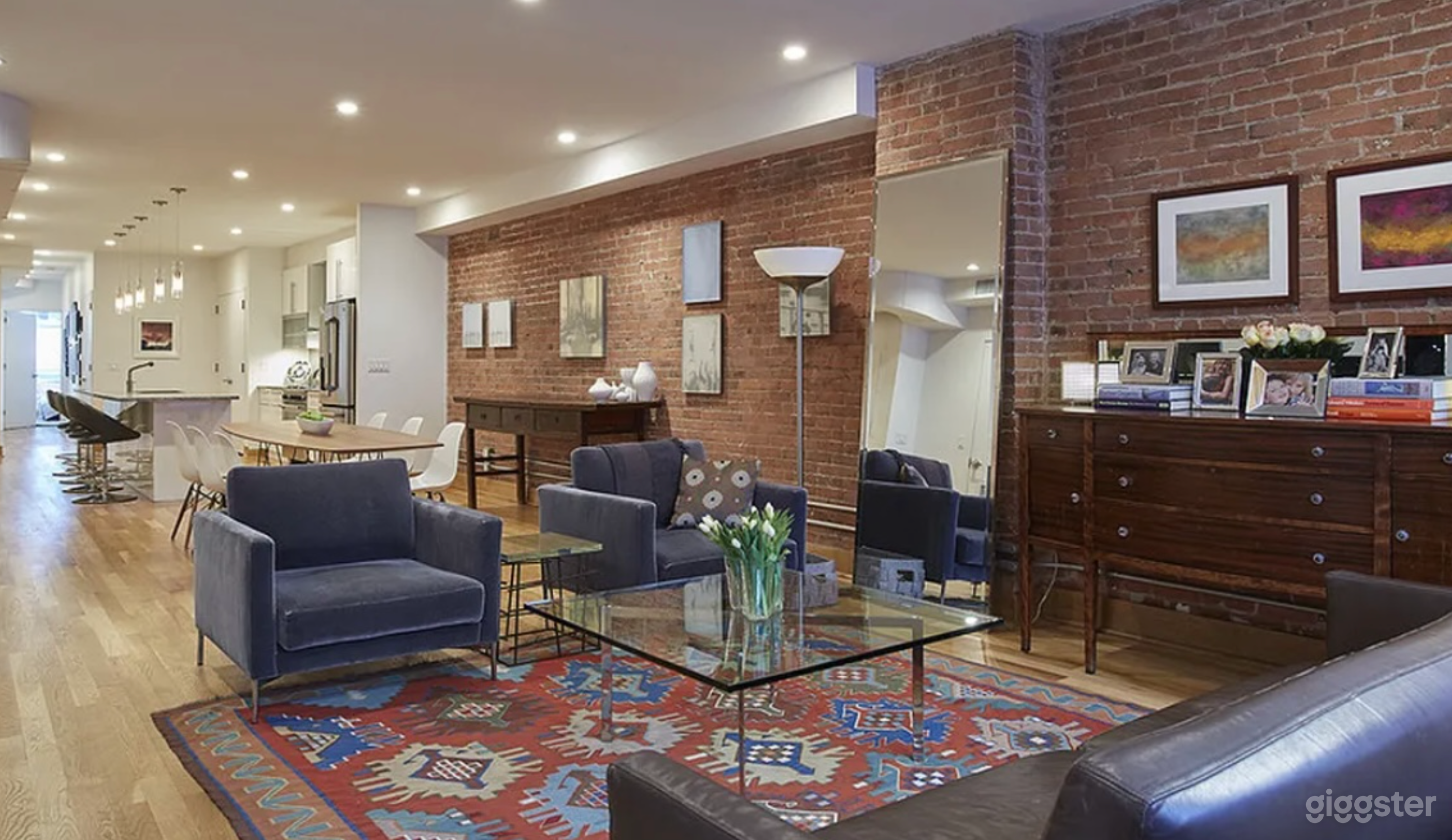 Expansive open living, dining and kitchen entertaining area. Furnished with a large dining table, comfortable lounge and bar area.