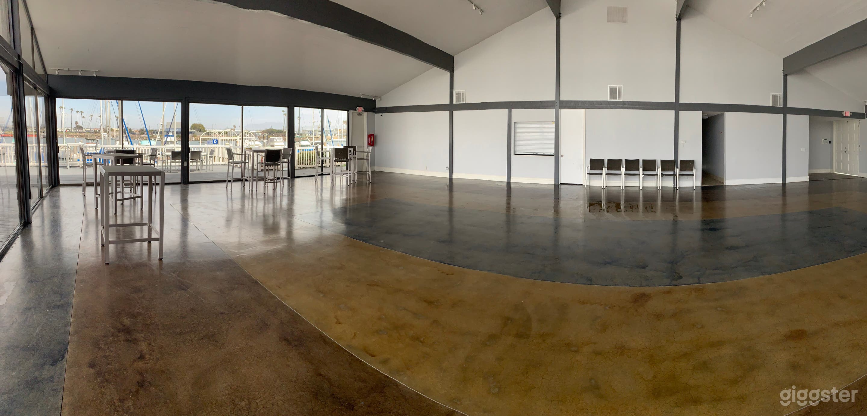Inside of the clubhouse. Some of the glass doors slide open and can be used for easy access to the deck and patio area. Bar area is also pictured here (where the door and roll-down window area are seen). 