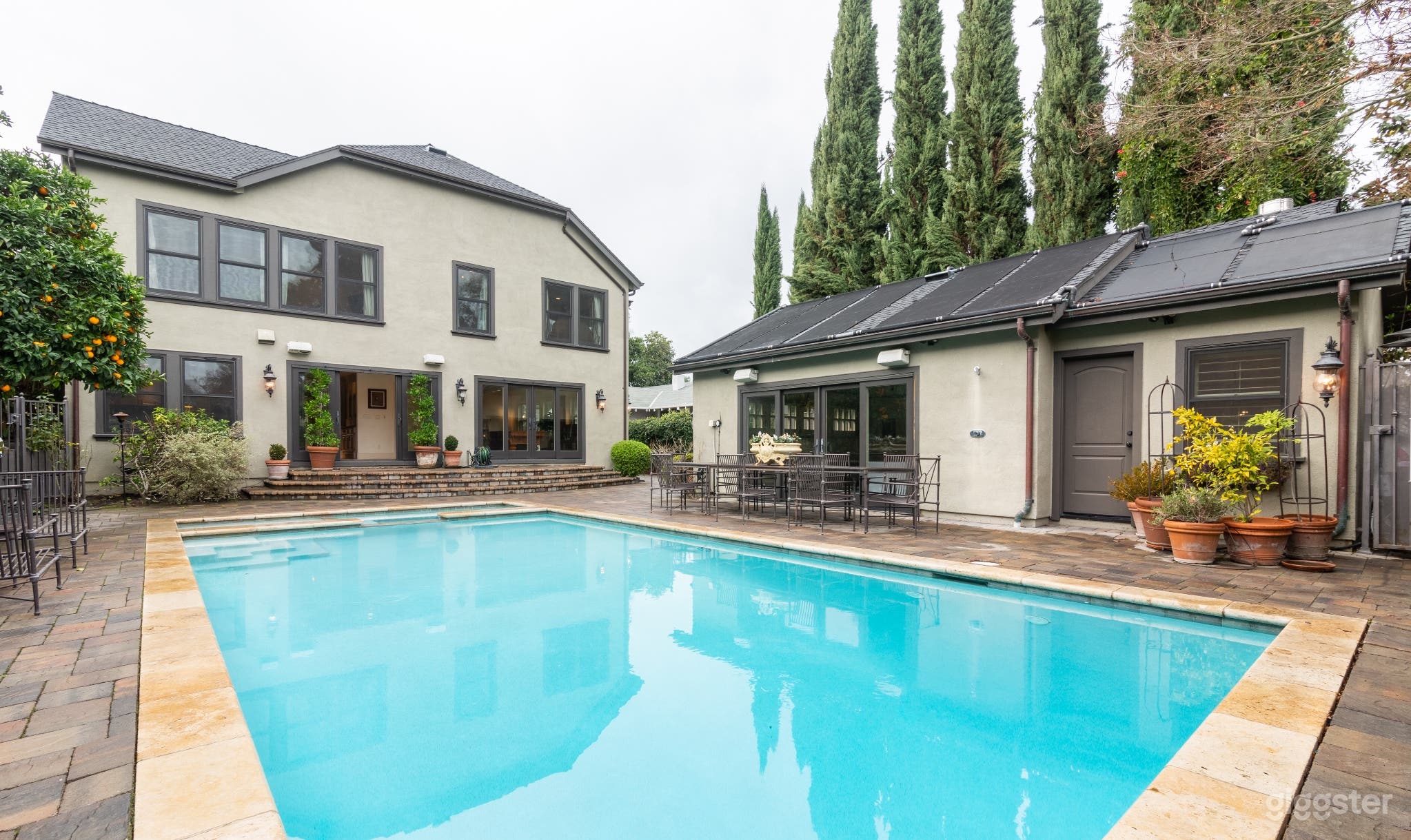 View of back of the house and detached garage/man cave, outdoor shower, private toilet and changing room