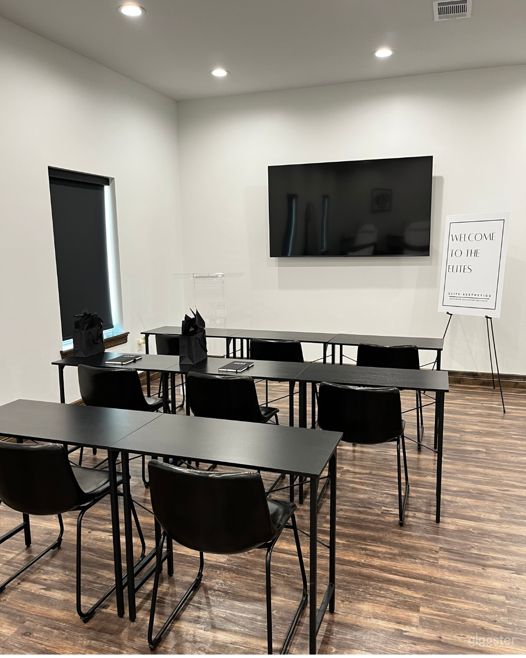 Large Conference Room - 8 individual desks and correlating chairs (Can fit more if provided, ie. table/ chair rental) Acrylic podium included. 65 inch TV with iPad available for mirroring capabilities. 