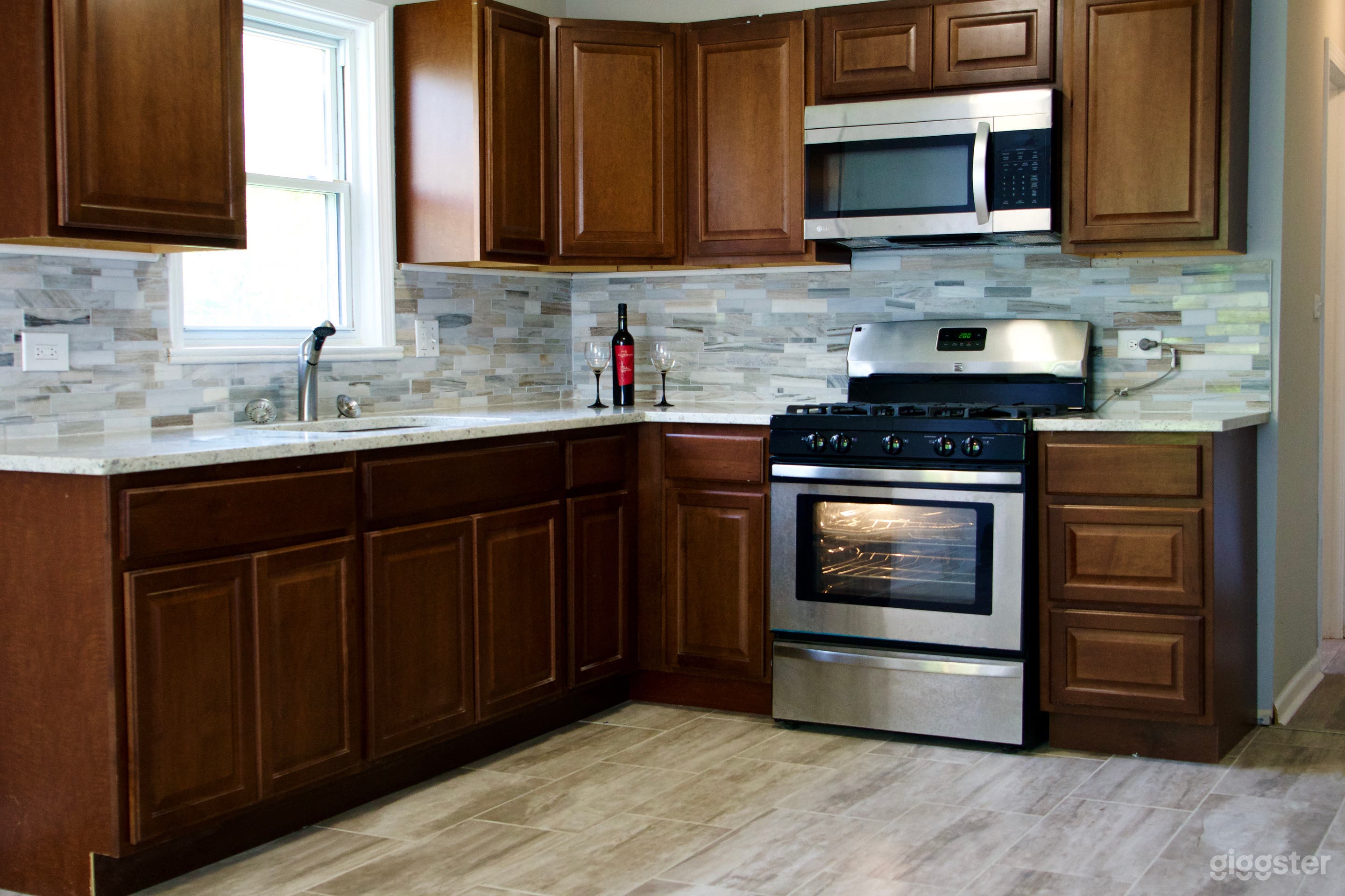 Spacious L-Shaped Kitchen with granite counters and wood cabinets. 