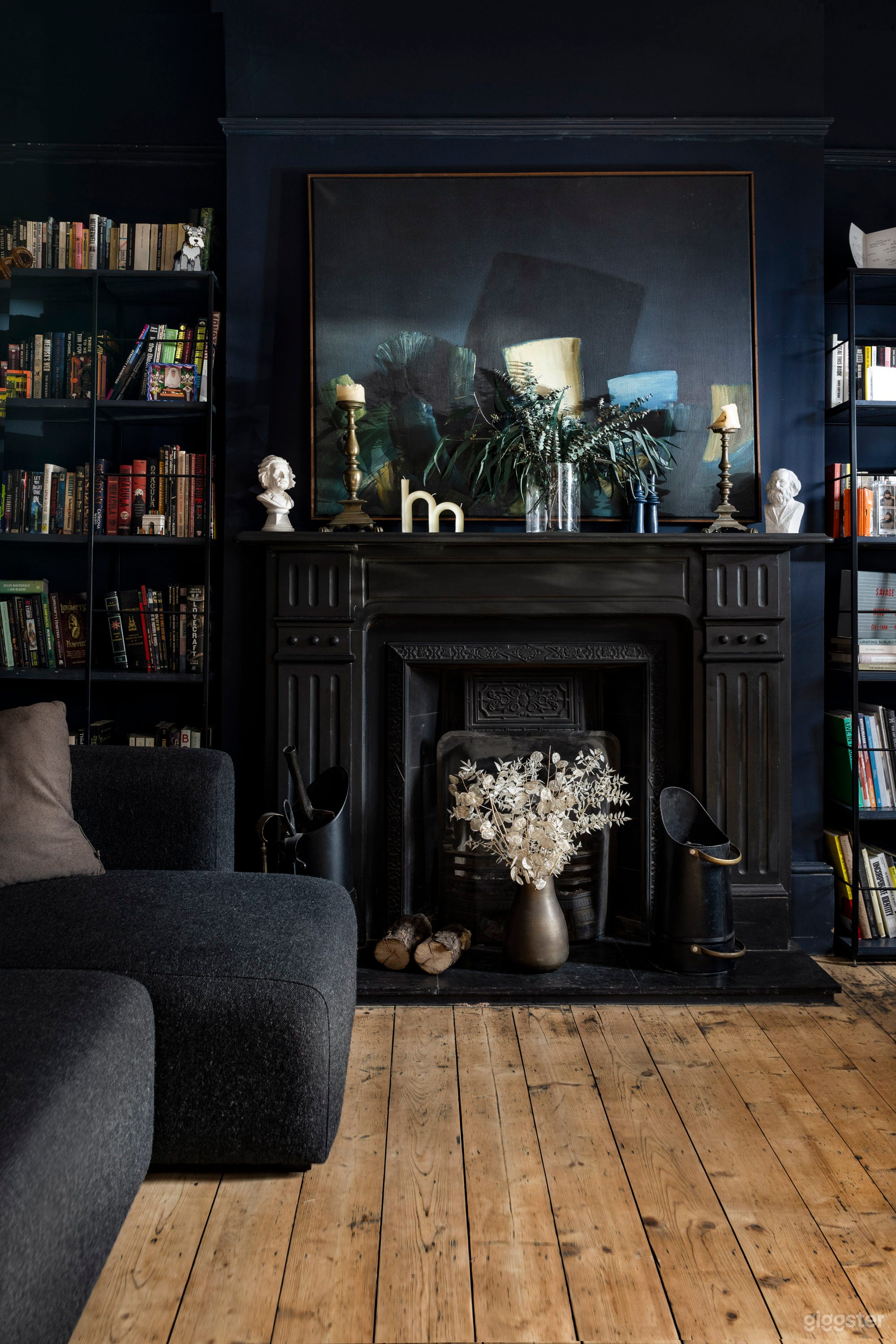 Front room/library/lounge with dark walls, high ceiling and original, working fireplace.