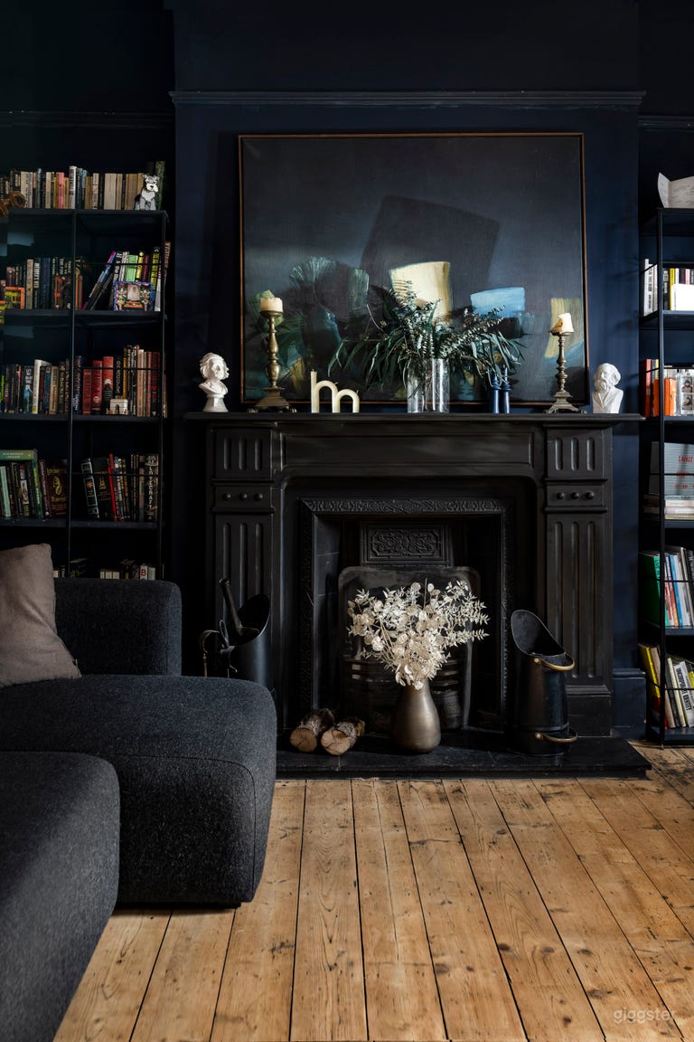  Front room/library/lounge with dark walls, high ceiling and original, working fireplace. 