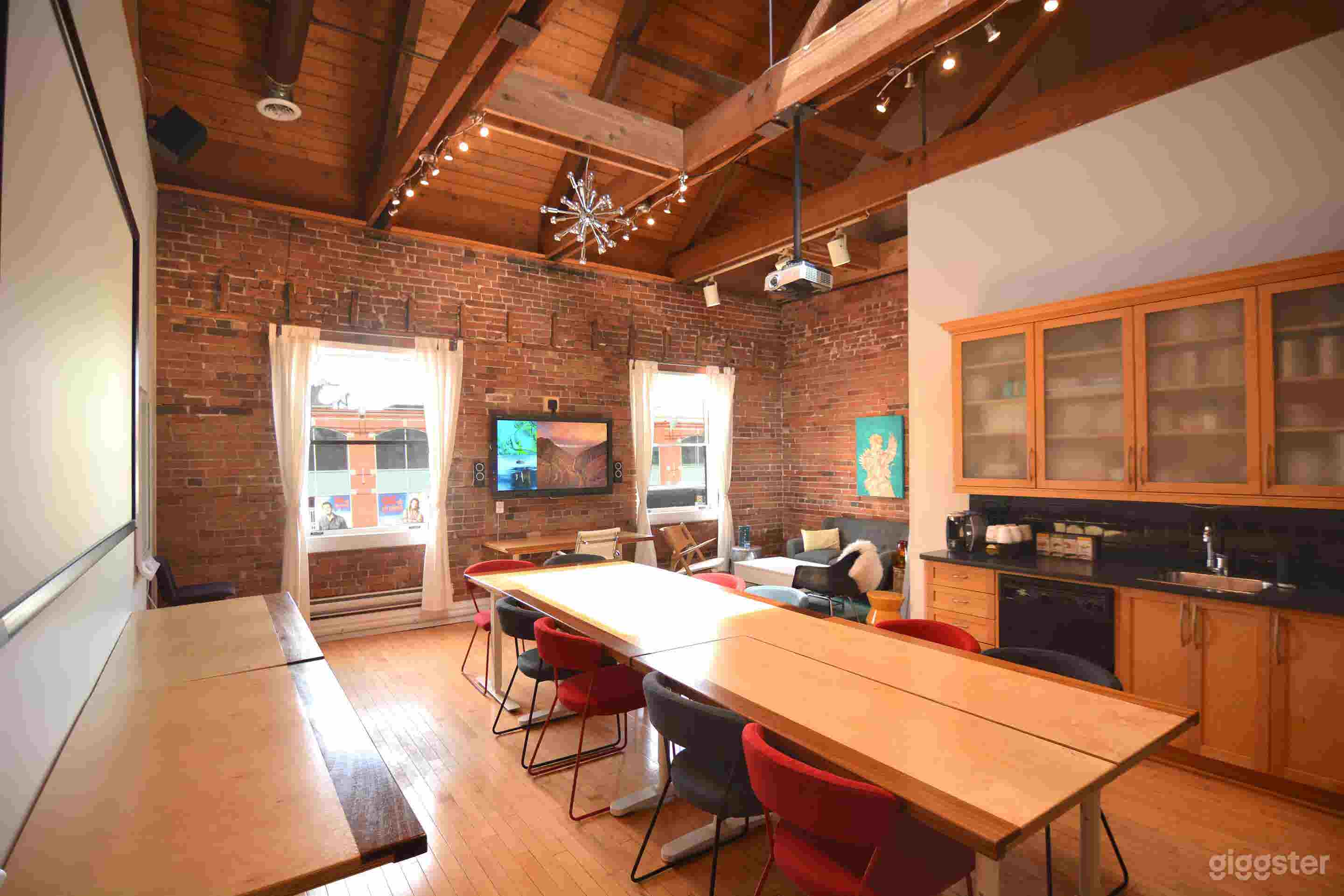 Boardroom setup with TV, whiteboard, Poly video conference, and kitchenette
