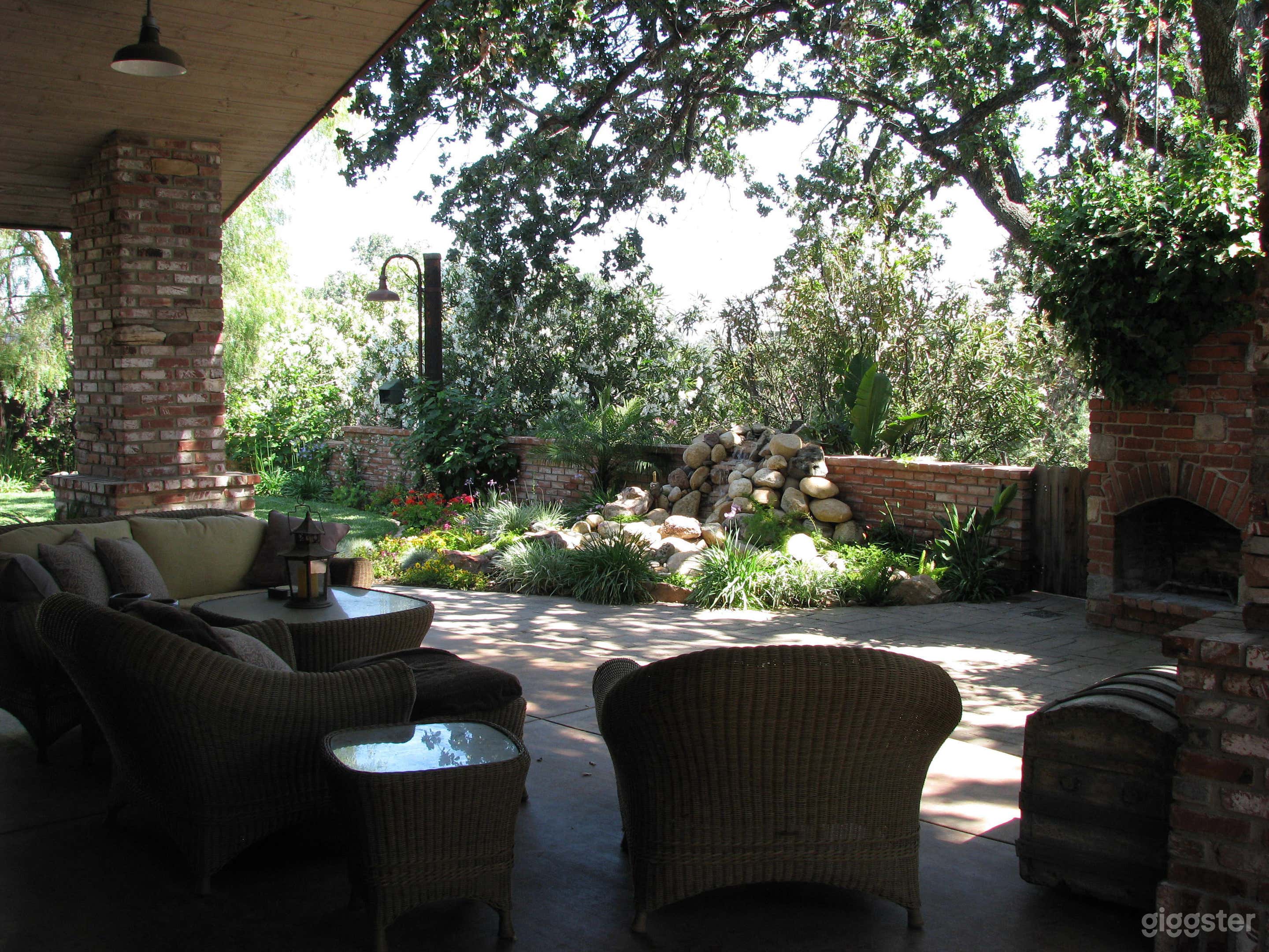 Covered patio with built-in outdoor fireplace/BBQ,  small pond and waterfall