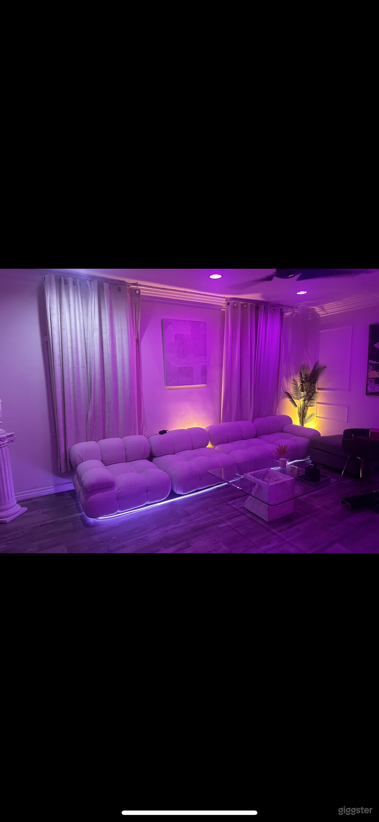 Living room with a Camaleonda sofa and high ceiling with Hue lights is a stylish and comfortable space for relaxing and entertaining.