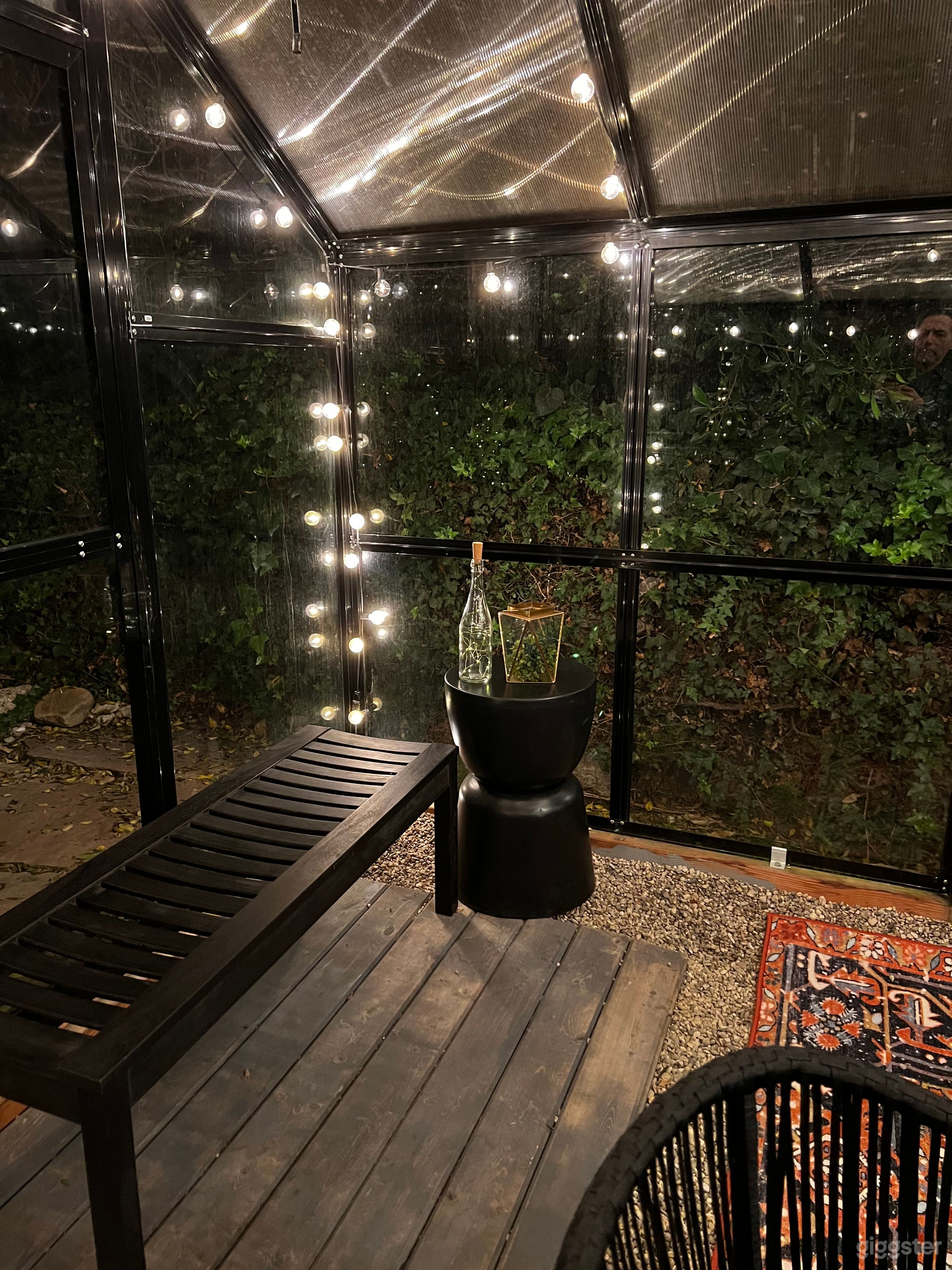 Small deck area with black wood bench, metal drum side table, romantic details