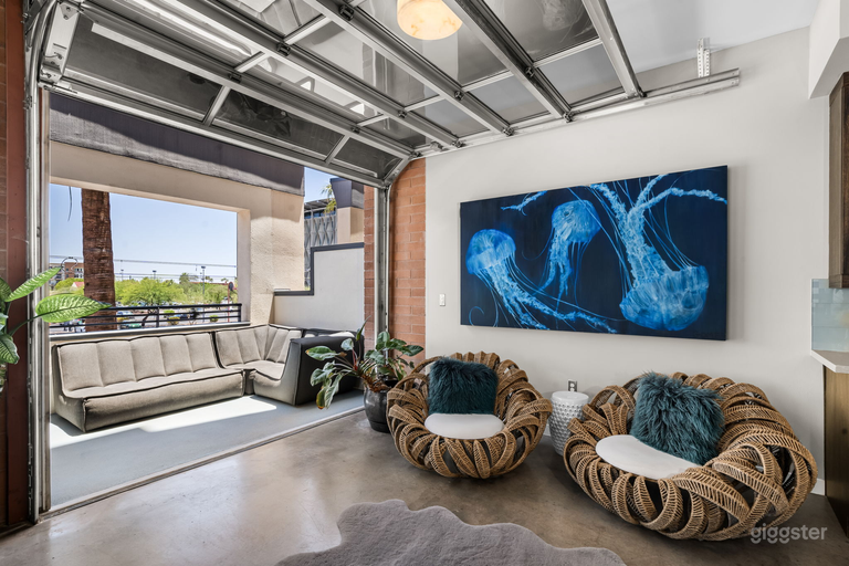  A common area adjacent to the kitchen.  It features two oversized custom chairs and beautiful artwork.  This space leads to the outdoor patio using the all glass garage door. 