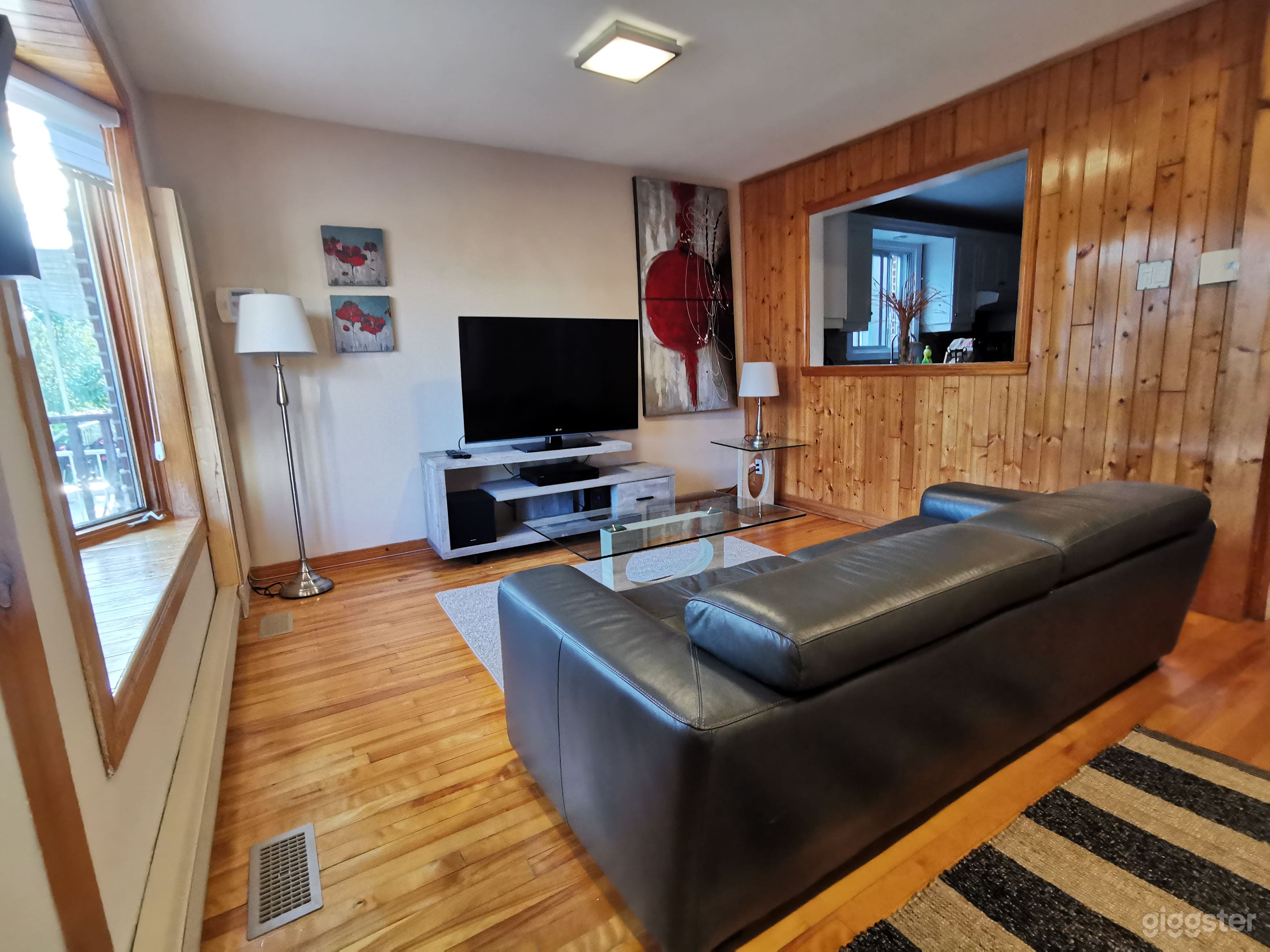 Living room with open view on the kitchen and wood wall
