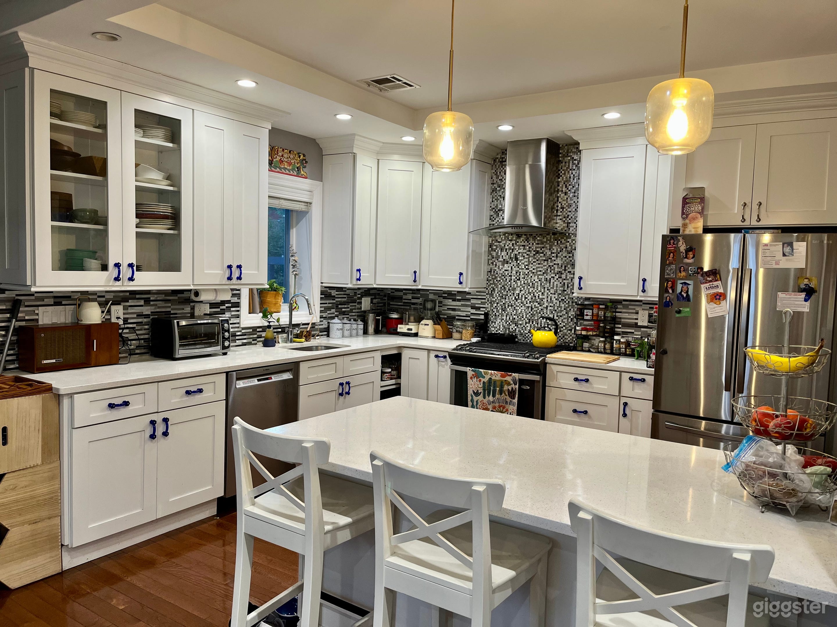 Open style kitchen with peninsula, modern lighting. Window above sink with view of backyard.