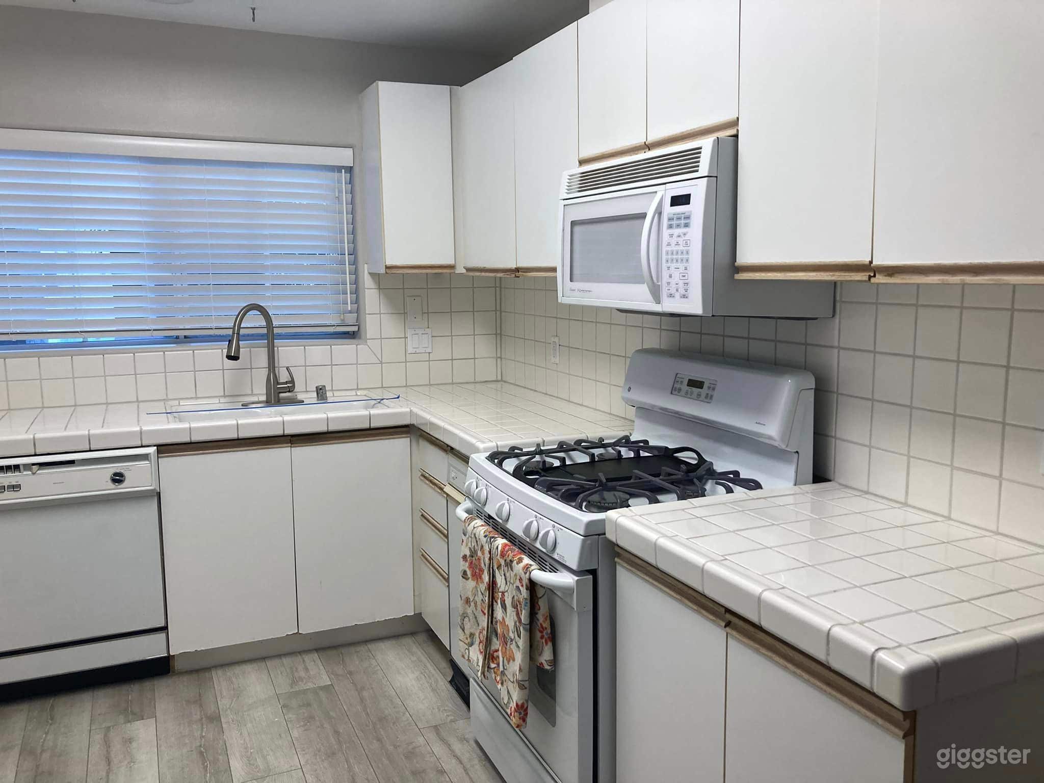 Galley Kitchen - Functional kitchen with seating area and two windows.