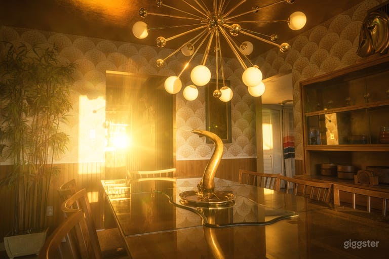  The dining room sets the tone with a full 1950s Conant Ball set, starburst chandelier, and gold leaf ceiling—just one glowing room in a home built for cinematic magic 