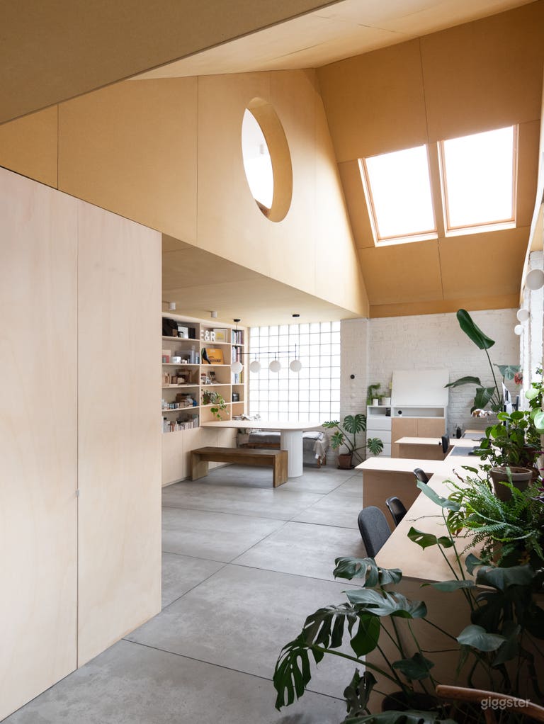  Main space with double height and yellow wood-clad ceiling and round window 