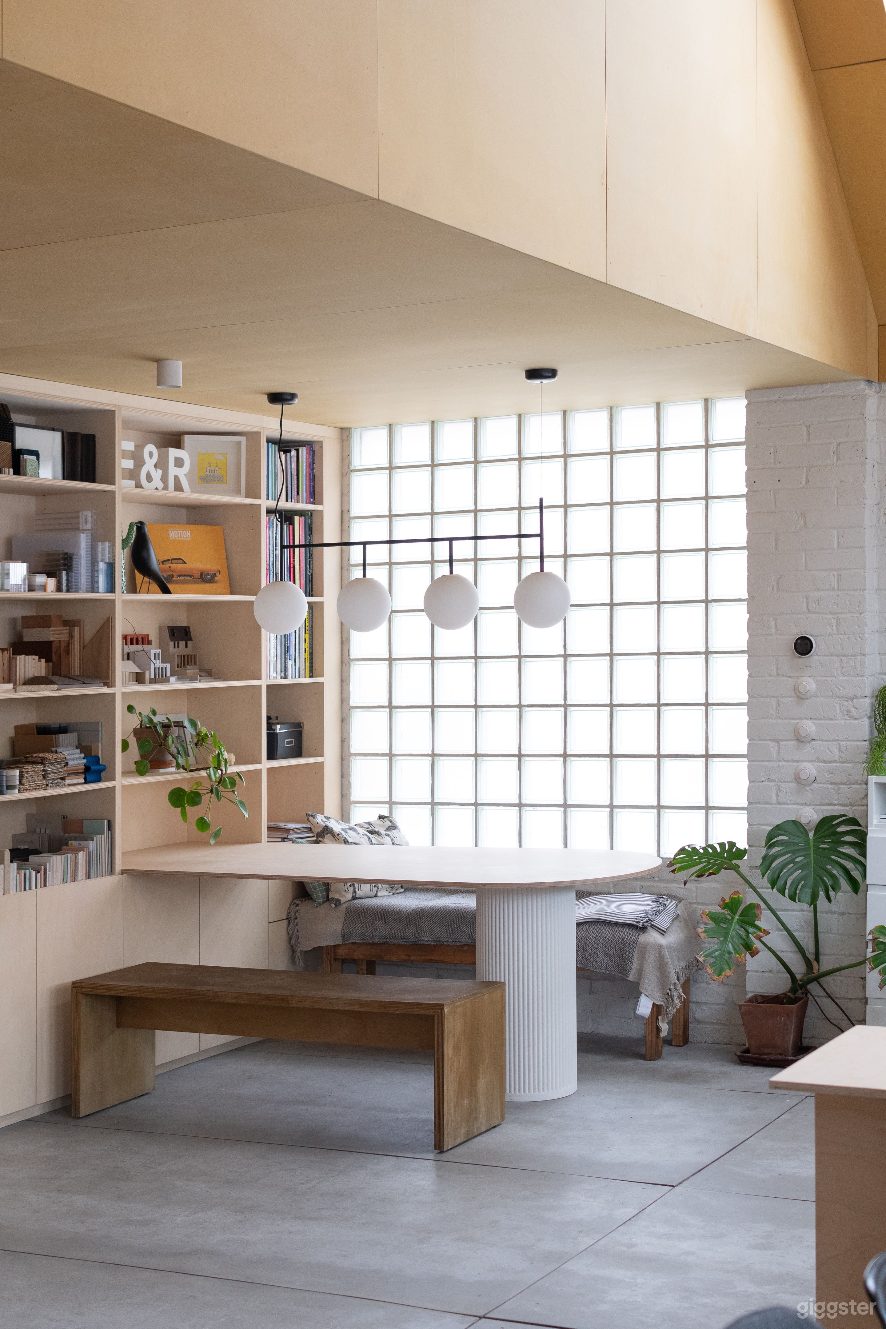 Plywood meeting table with glass brick window and plants