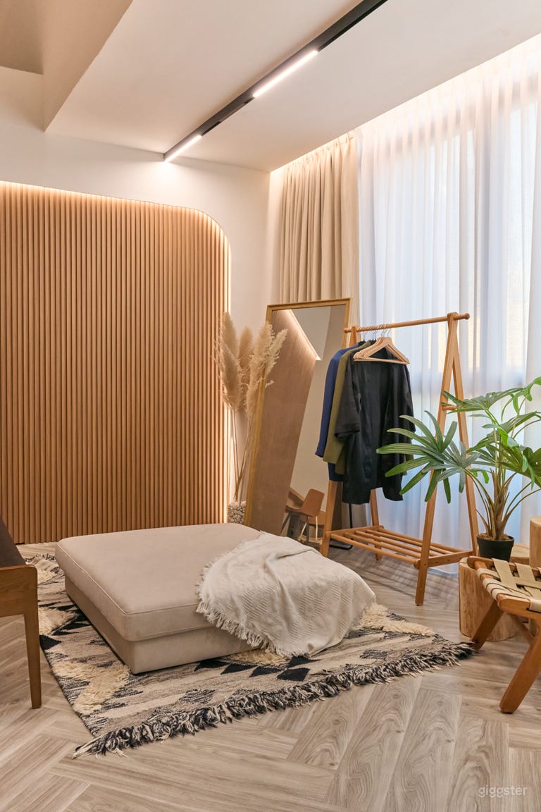  The studio features a stylish lounge and dressing area, complete with a full-body mirror set against elegant floor-to-ceiling windows. This inviting space is perfect for preparations, relaxation, or enjoying natural light while enhancing your creative expe 