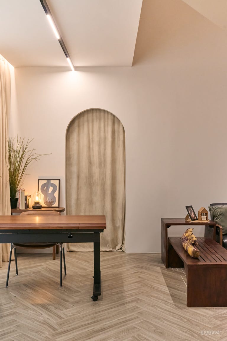  The studio includes a cozy reading nook and study table area, featuring an adjustable standing desk set against a stunning arched cove backdrop. This space is perfect for creative work, meetings, or relaxing moments, blending comfort with a visually appeal 