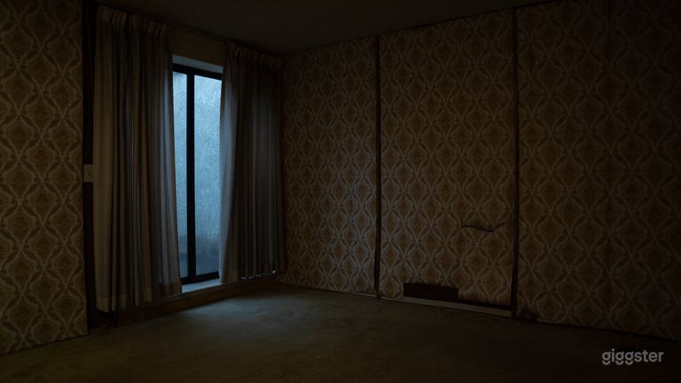  Empty Bedroom with vintage wallpaper and ugly wood paneling underneath. 