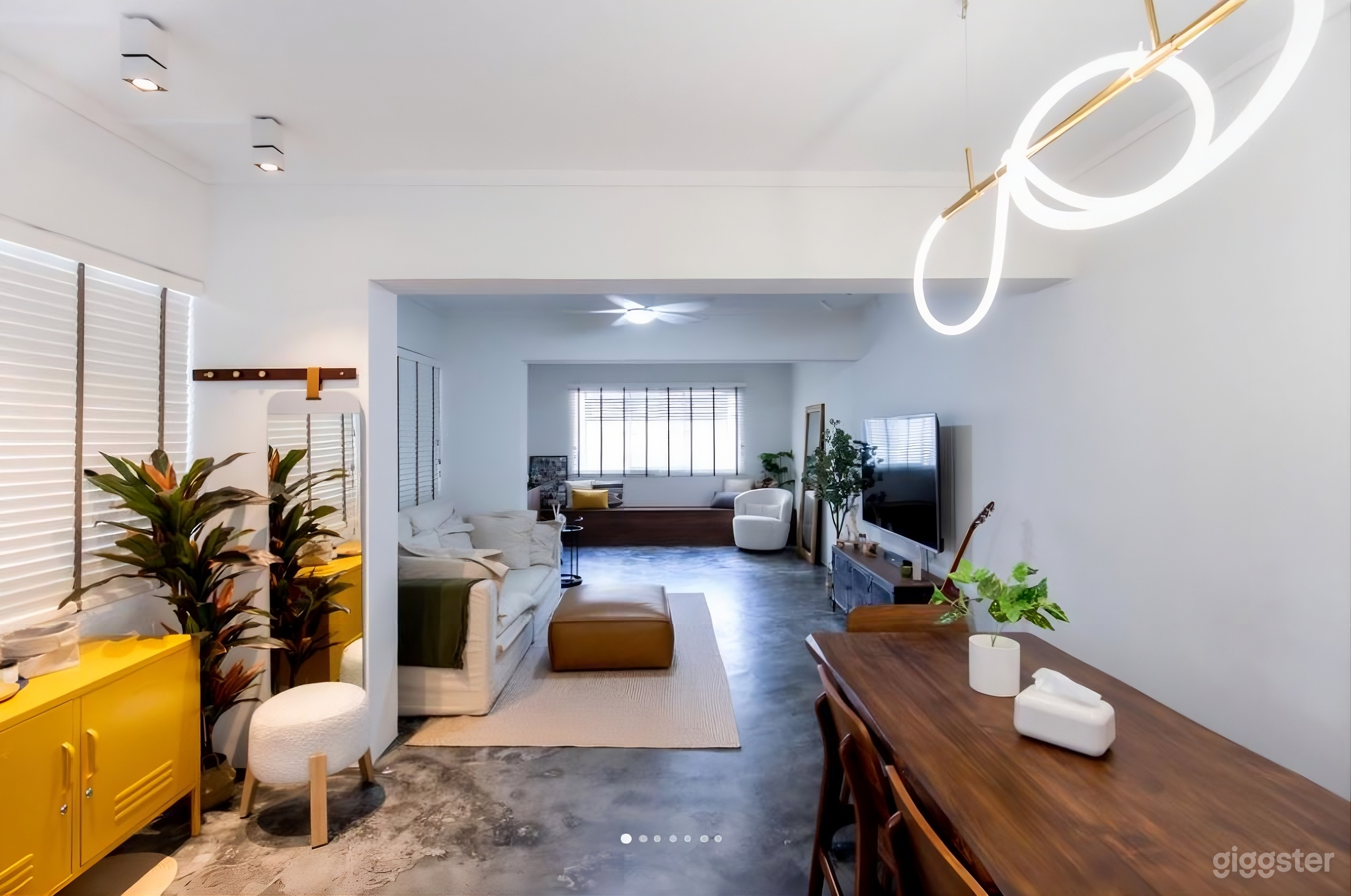 Open concept with cement screed flooring and dark wood pairing balanced with soft textures of rug and sofa