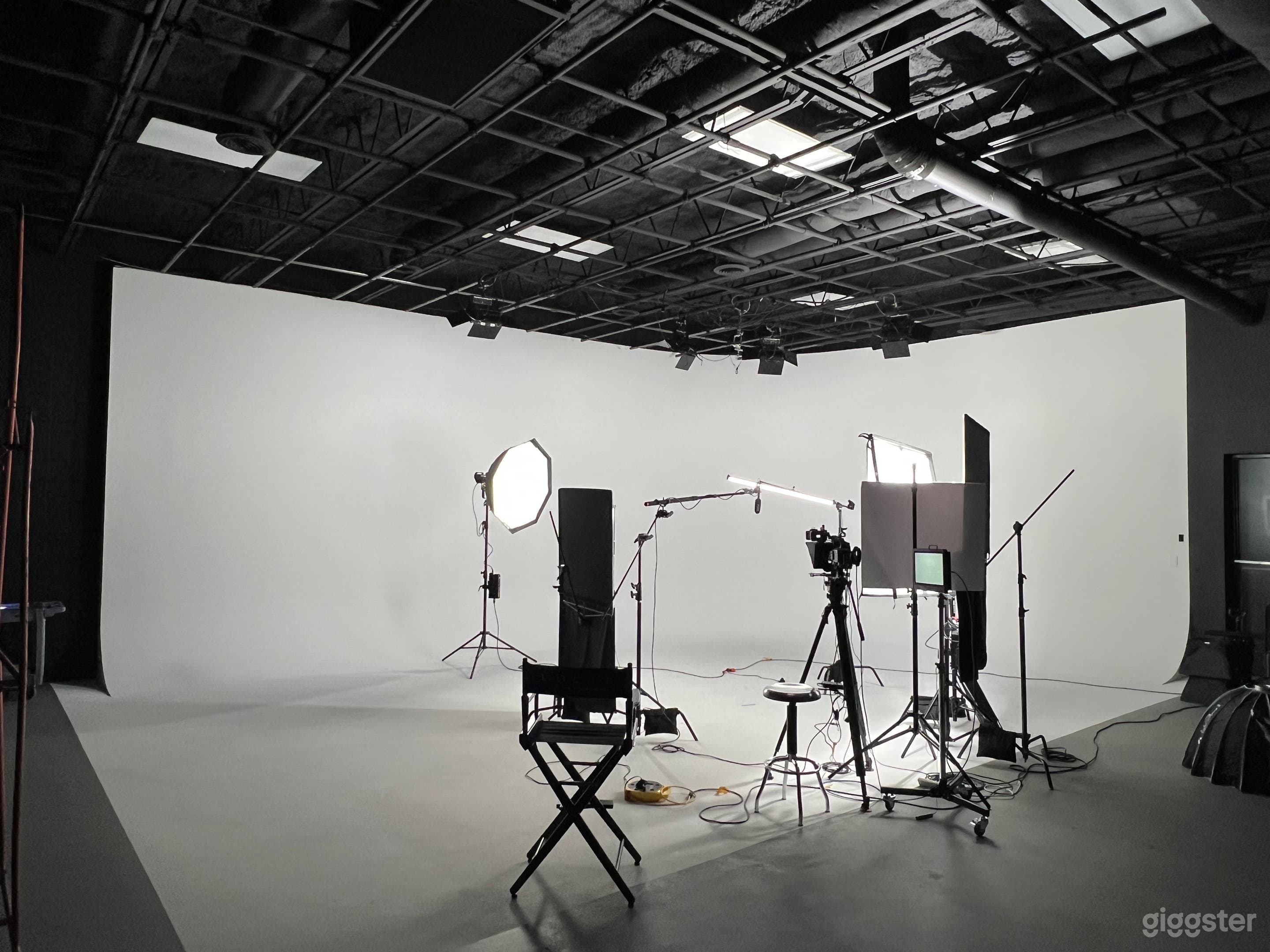 Spacious studio with cyc wall and lighting equipment.