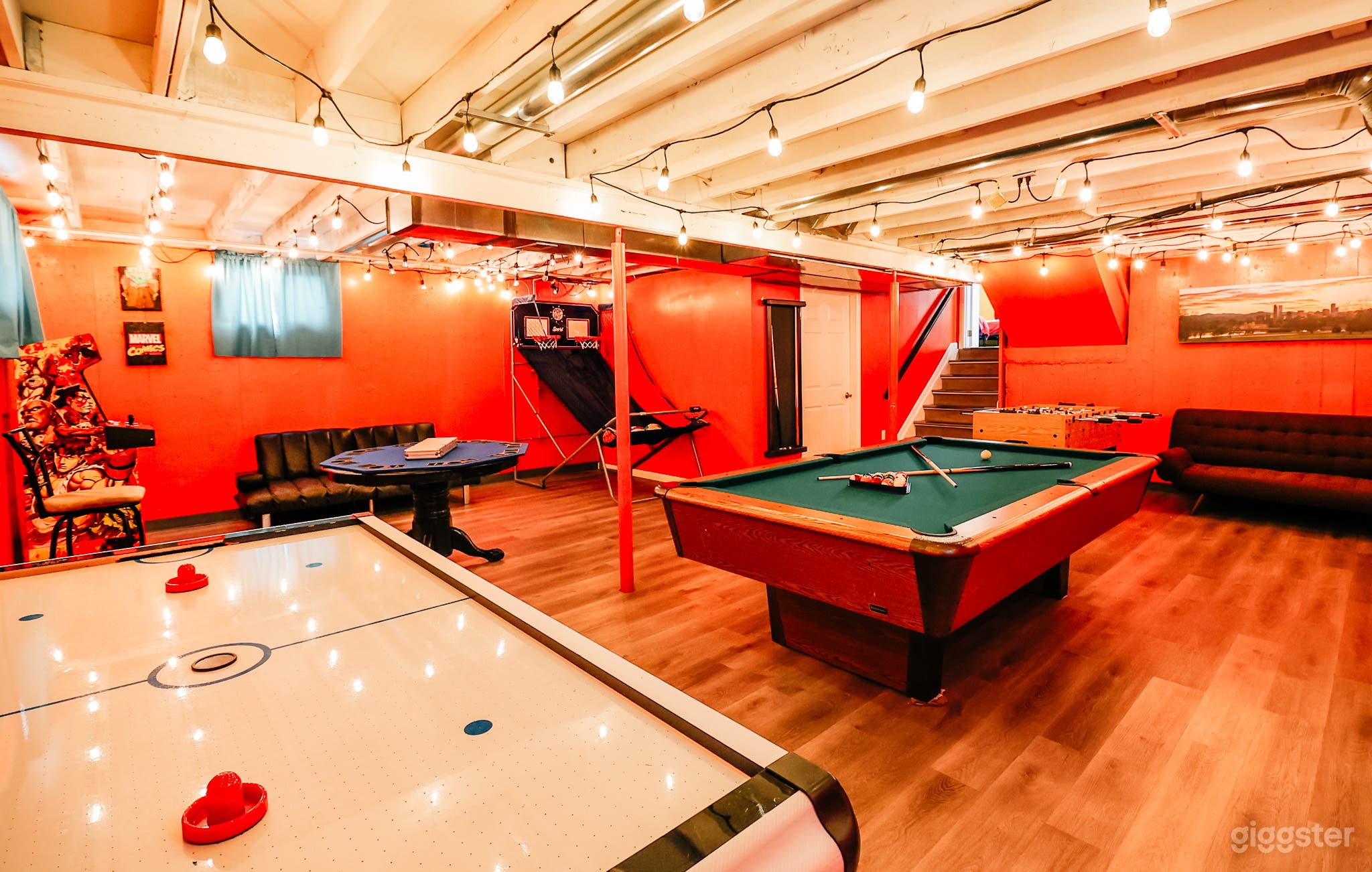 The bold red wall of this game room energizes the space, creating an electrifying backdrop for epic battles and laughter-filled evenings.