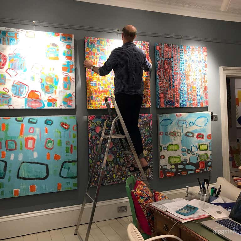  Art work being hung on the walls using a picture rail and gut with hook. Note professional spot lights. 