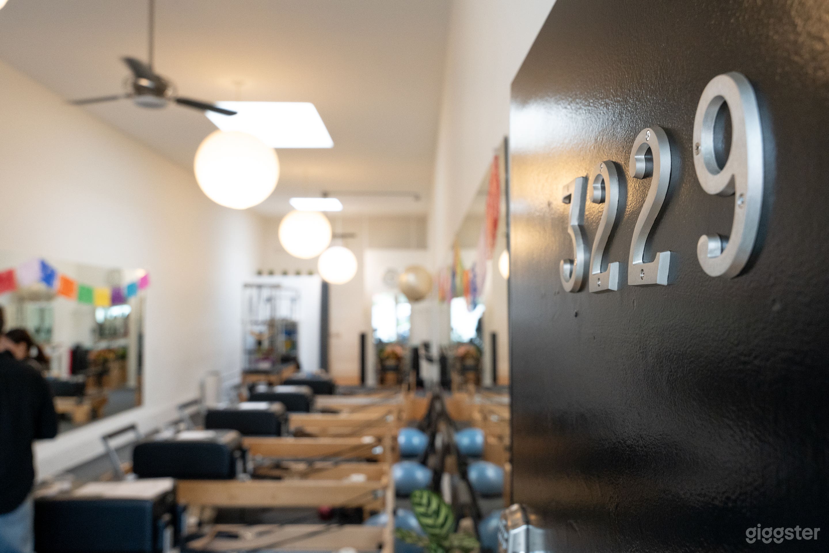 The bright interior of this Santa Monica Pilates studio features natural light from skylights and large windows. Equipped with Balanced Body Reformers, the clean, modern design creates a serene atmosphere ideal for photo and video shoots.