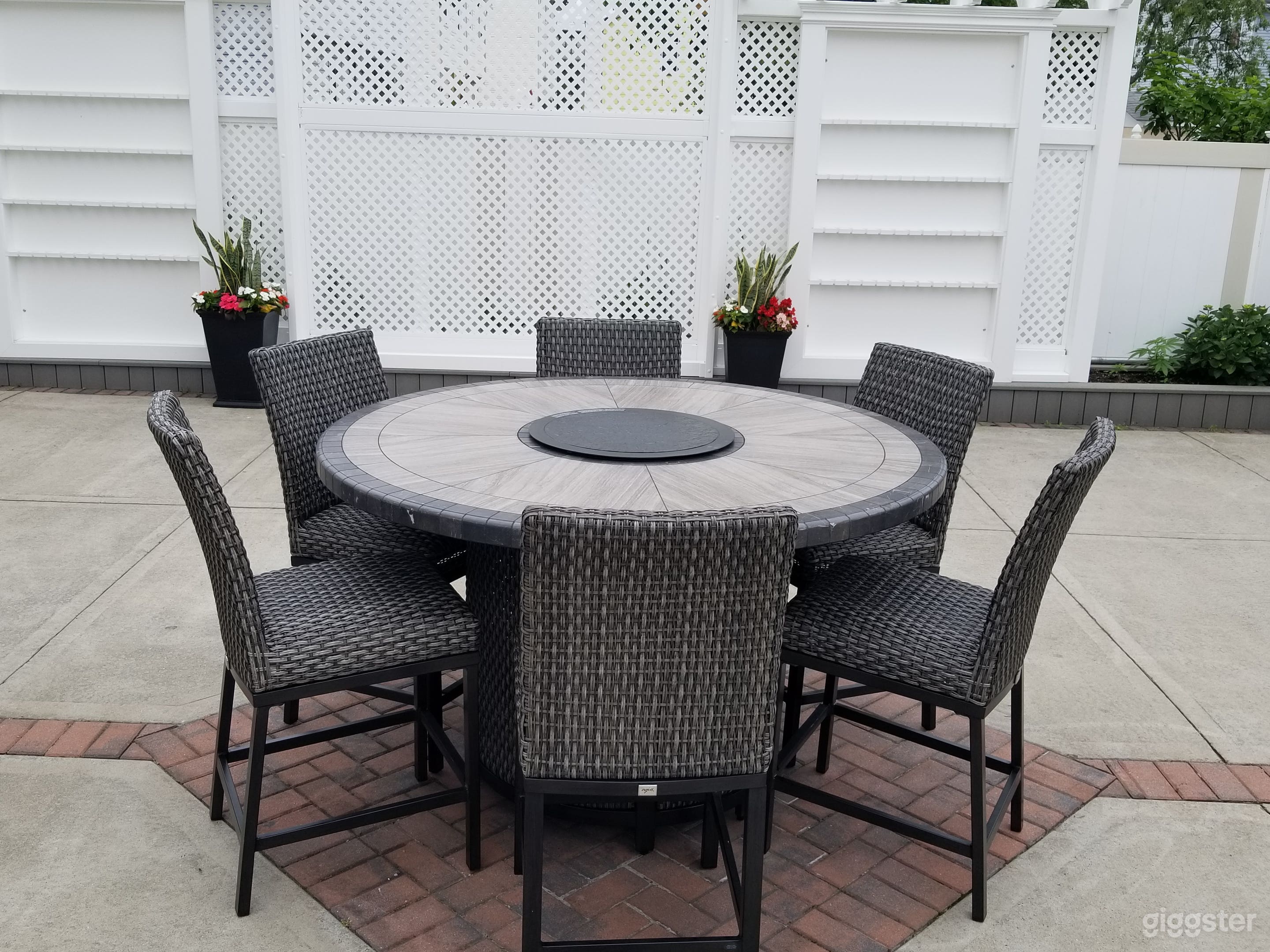 Eating area in backyard with 2 champagn walls and decorative wall in middle.