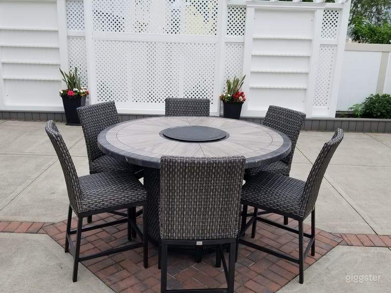  Eating area in backyard with 2 champagn walls and decorative wall in middle. 