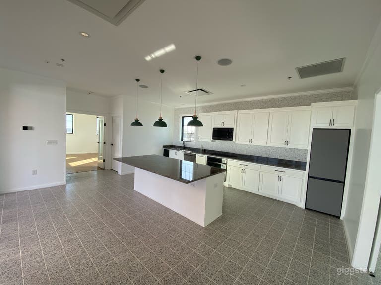  Open Kitchen area. Island in the center, there is a stove, oven, sink, and refrigerator.  