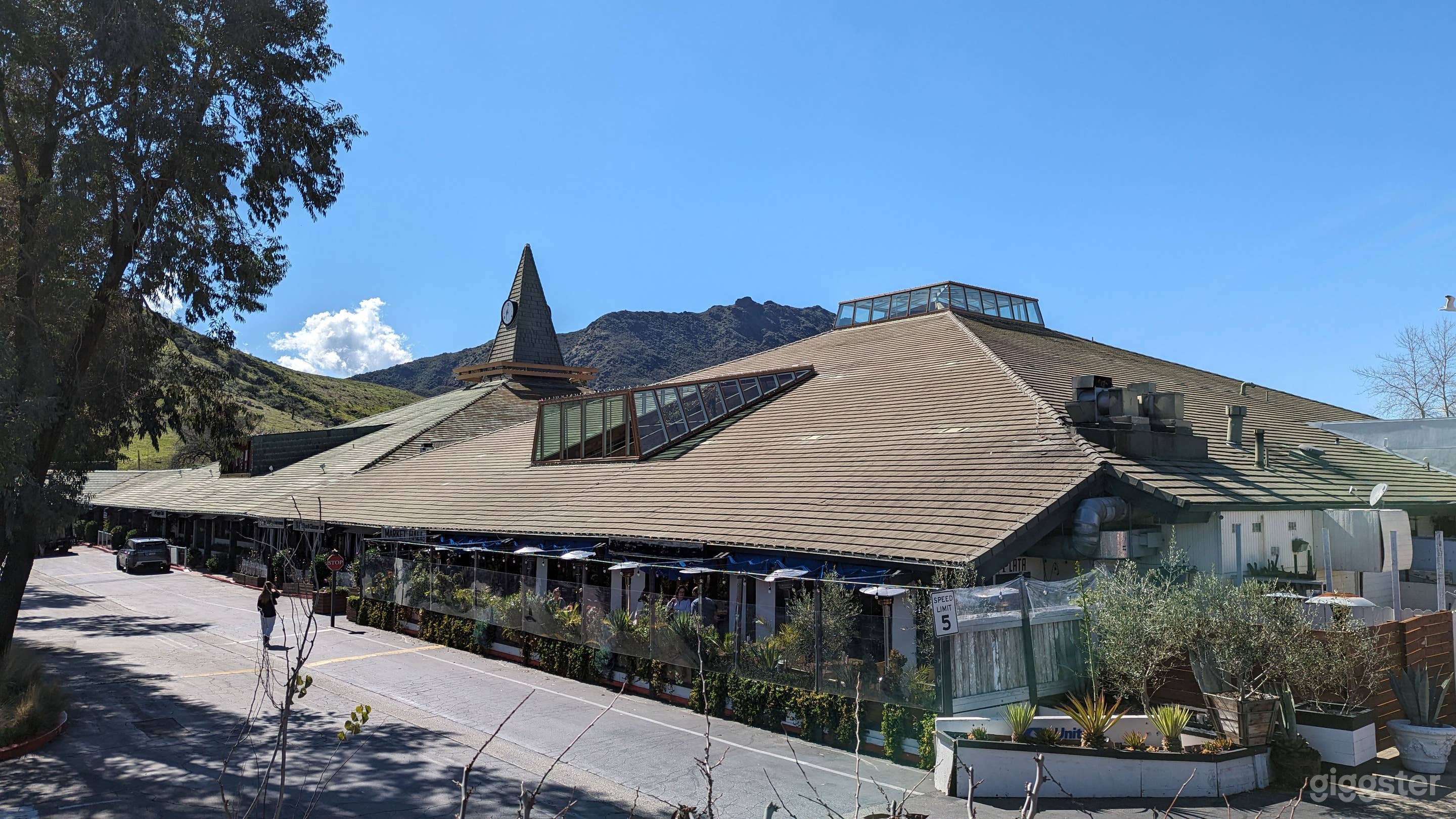 A large building next to ample parking with the Santa Monica Mountains in the backgrounds is a perfect settting