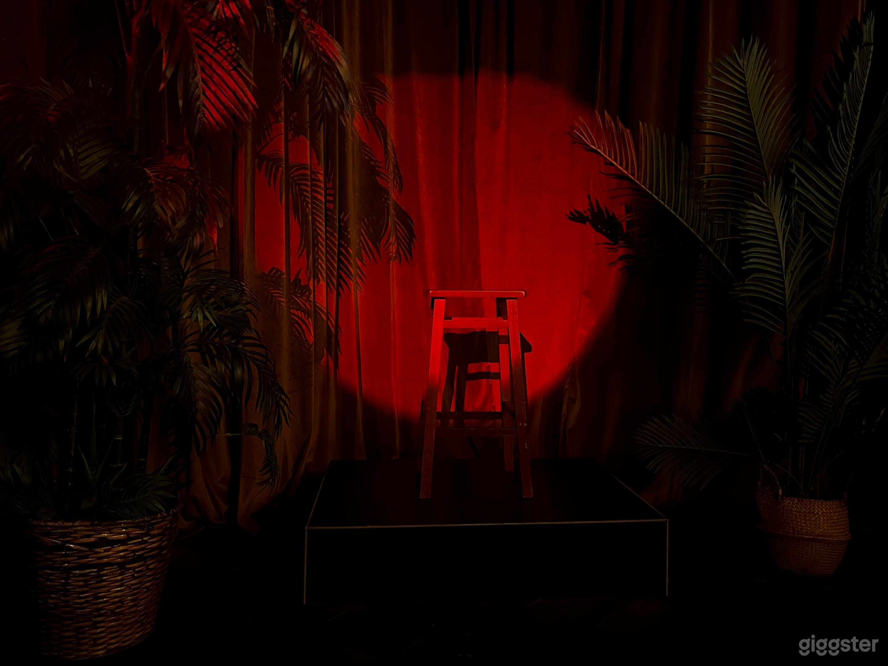 Bar set, LED lights, liquor bottles decor, red bar stools, stage, accent lounge chairs.