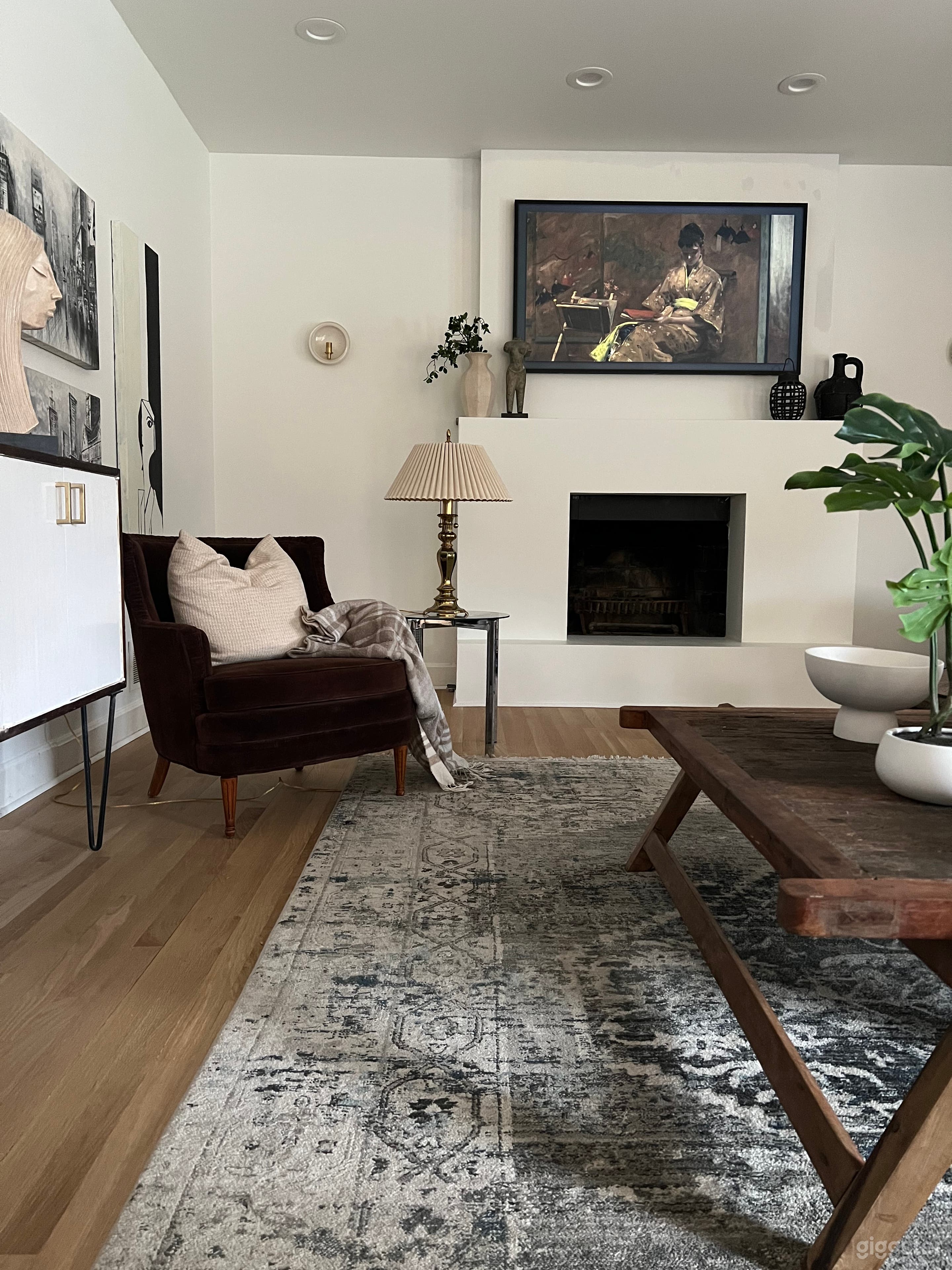Large living room with eclectic furnishings, large windows. 
