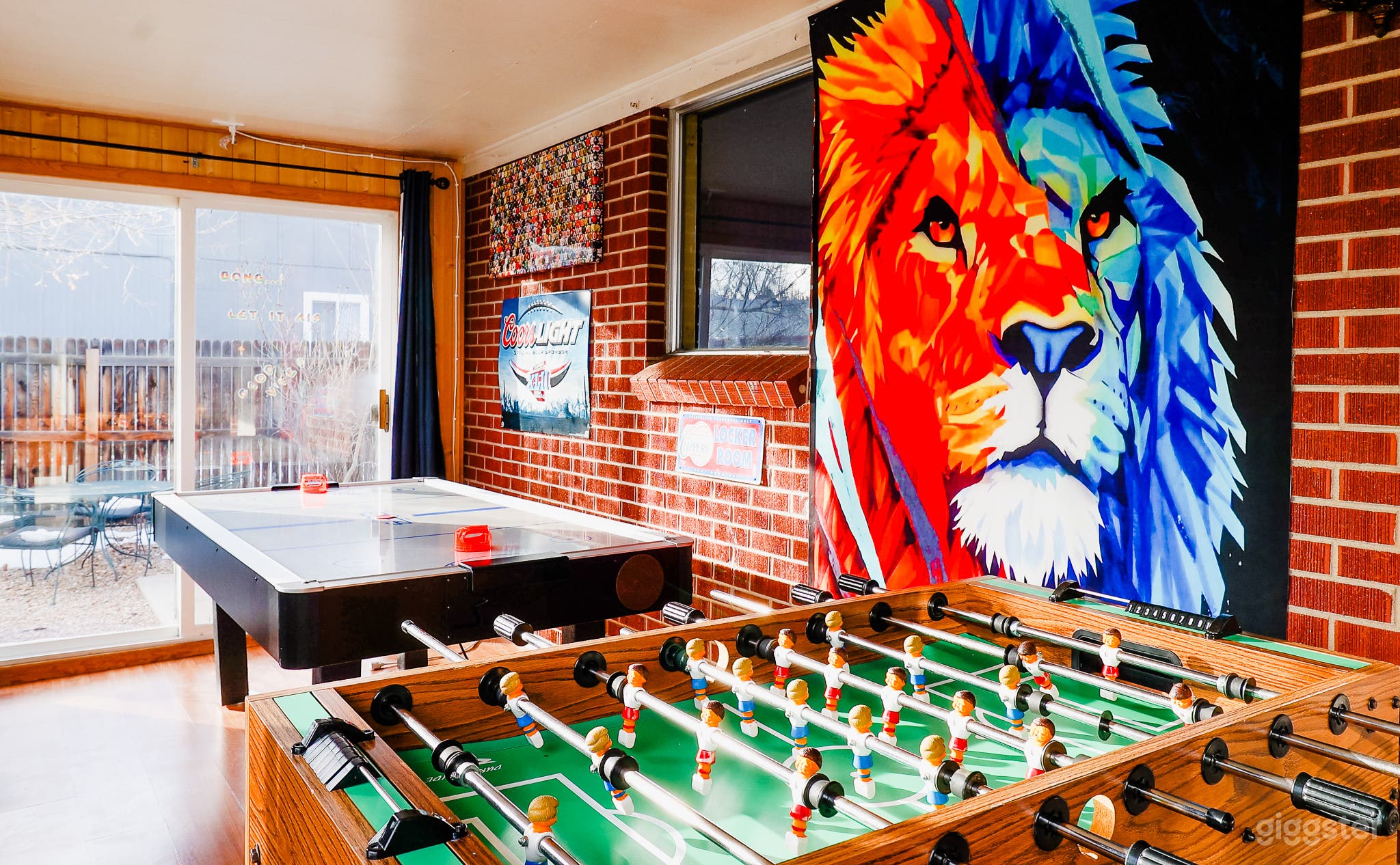 A striking lion painting dominates the game room, infusing the space with a sense of wild beauty and adventure amid entertainment options.