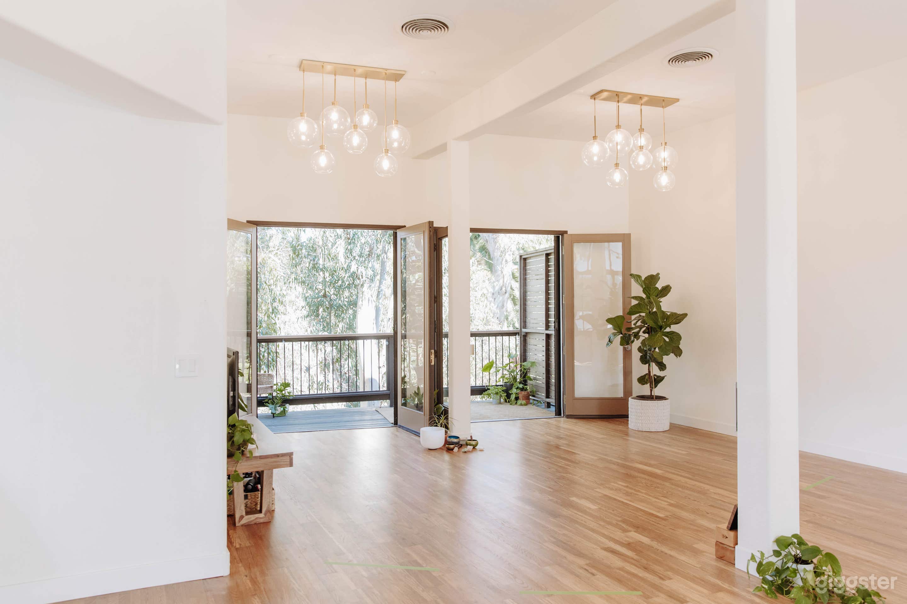 Main studio, spacious open floors, large blank wall, two sets of double doors that open to deck with canyon view. Please note: tables and chairs are not included.