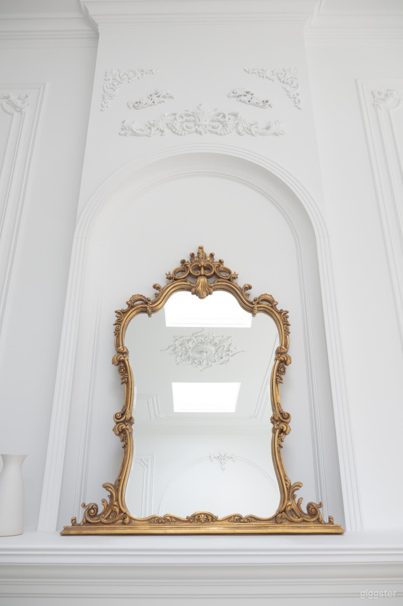 Vintage antique mirror adorning a grand fireplace, adding timeless charm and elegance to the studio space