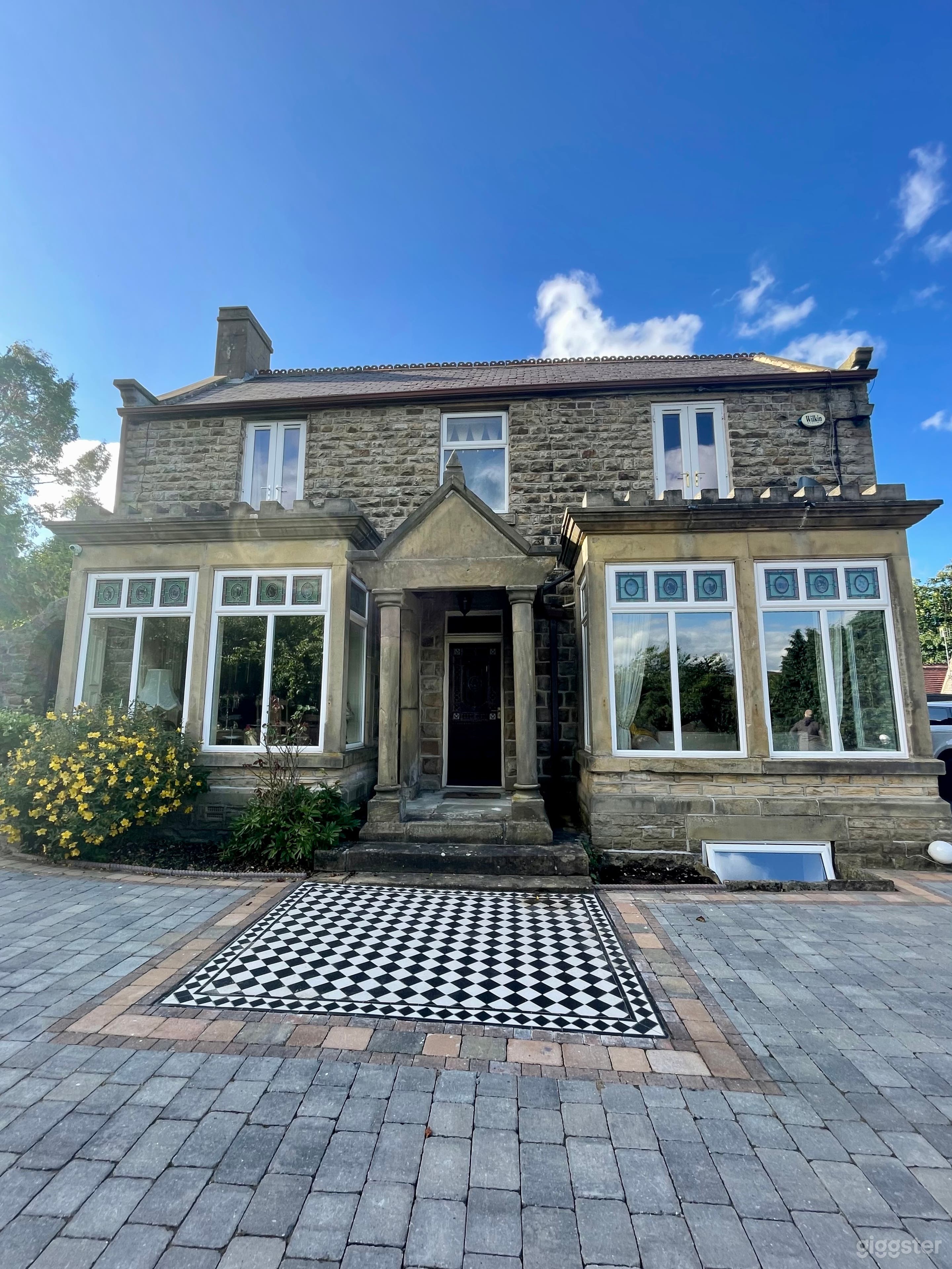 Front of the house. South facing. Black and white Victorian floor tiles and grey/red block paving to large front yard. 
