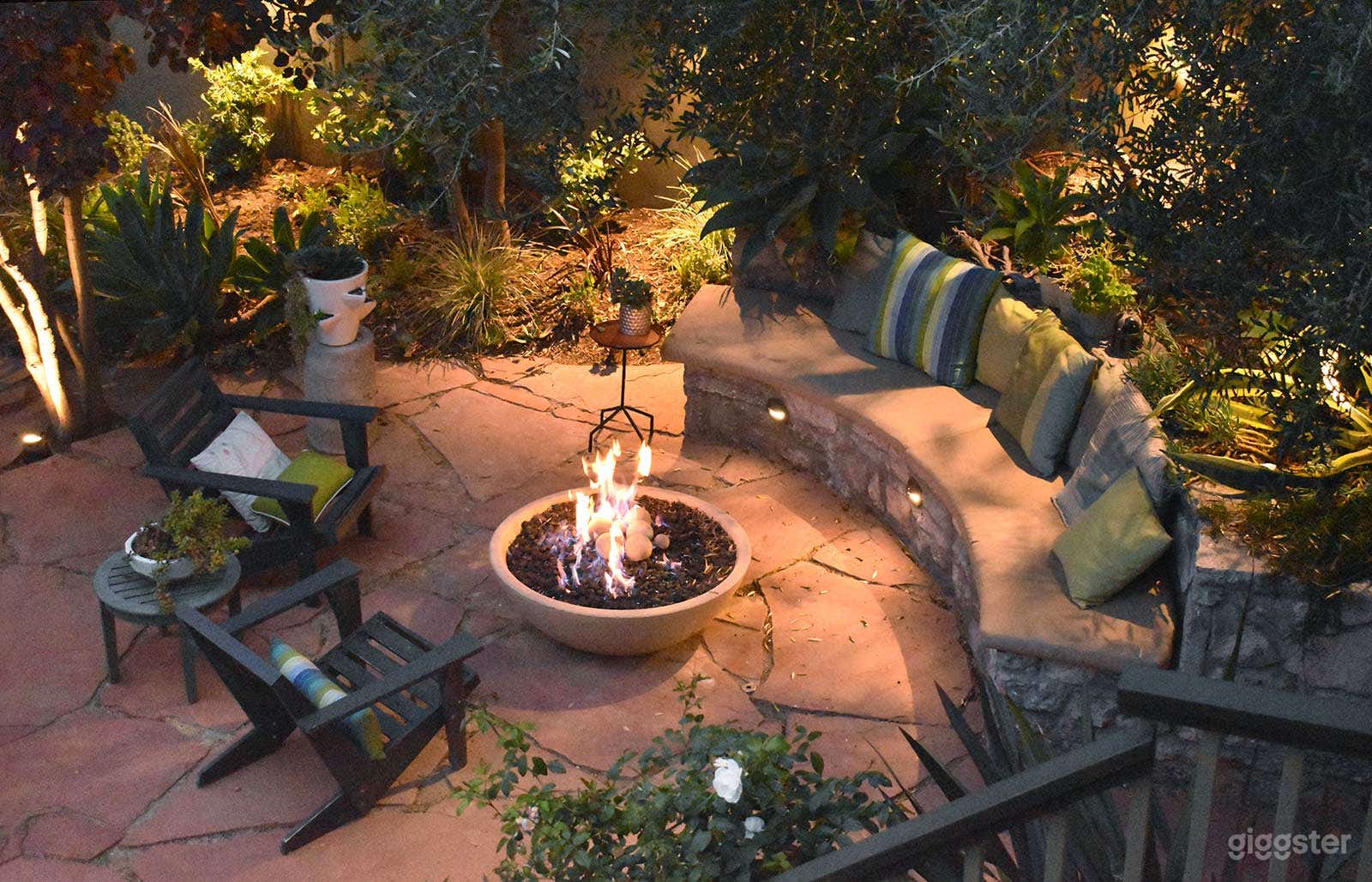 The property features an award winning garden with a   gorgeous stone bench and fire pit. Sip drinks by the pool or sit by the glow of a warm fire at night. The two-story rear studio and staircase also offer spectacular camera angles for the perfect shot.