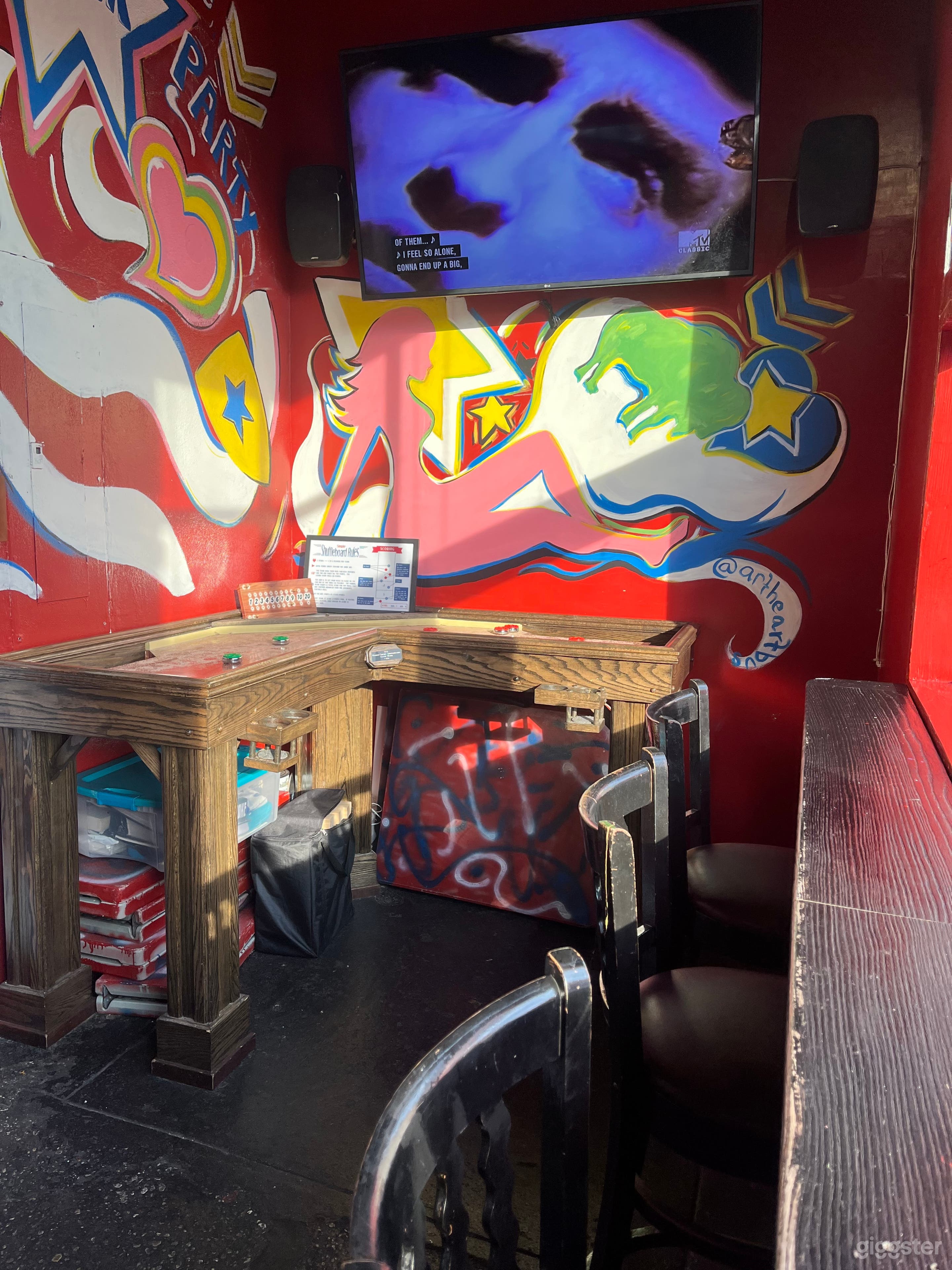 Our front room with wall mural and corner shuffle board table