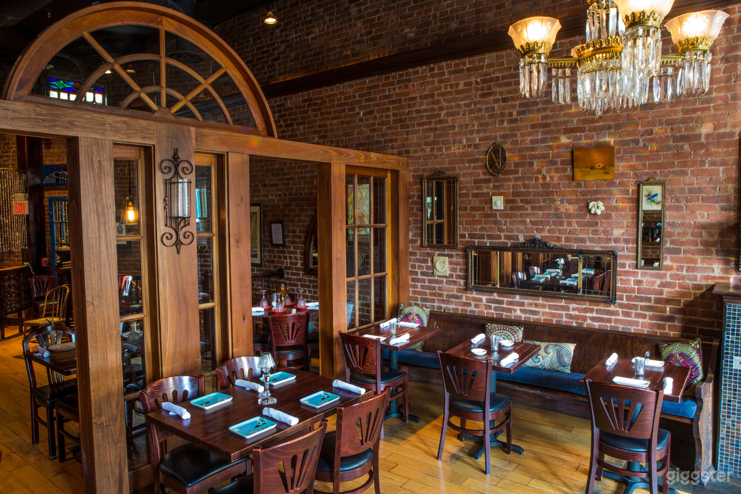 The median in the second floor dining room; it is a permanent feature and creates a semi-private space for smaller events. Exposed brick throughout, and a chandelier.