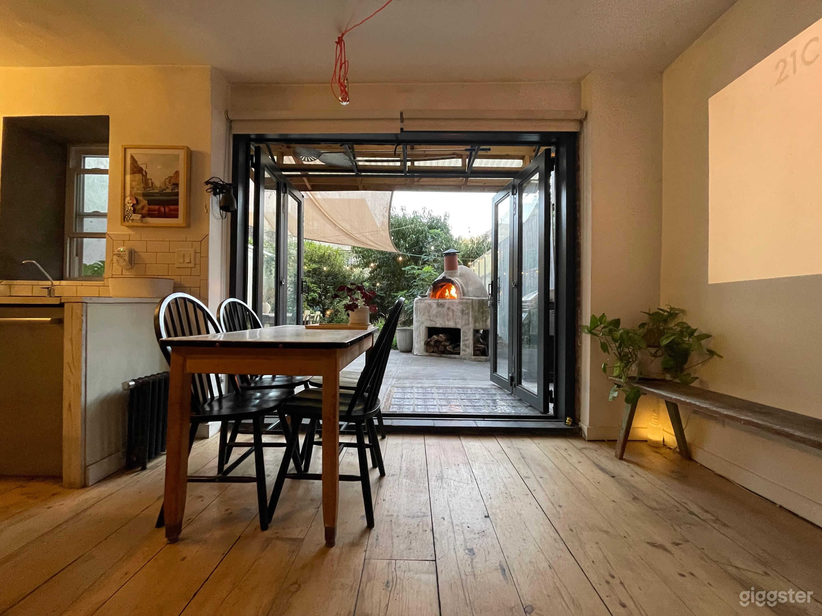 Livingroom with reclaimed beam flooring, onto garden with raised beds and pizza oven