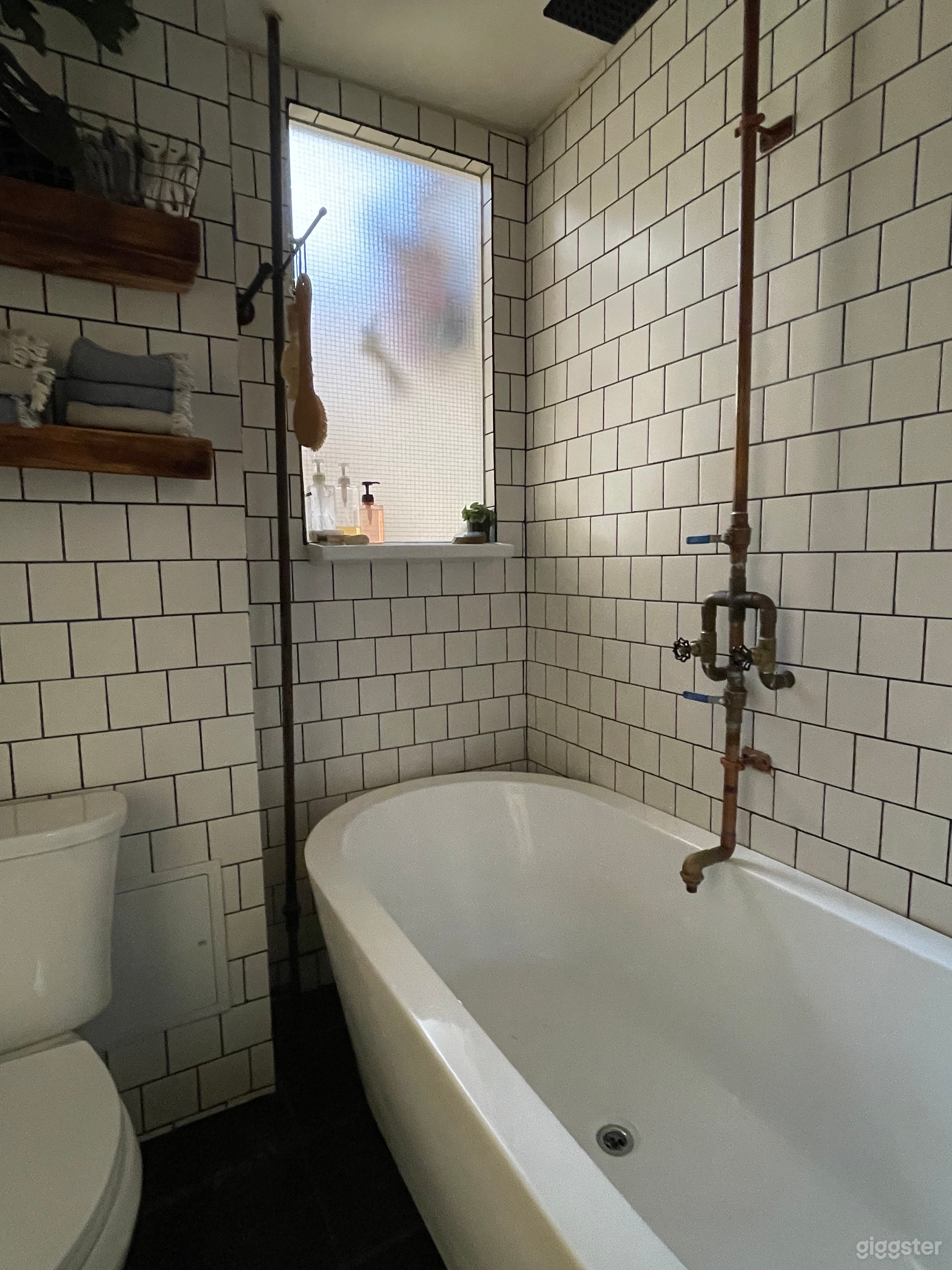 Bathroom with natural light, large tub and custom copper industrial fittings