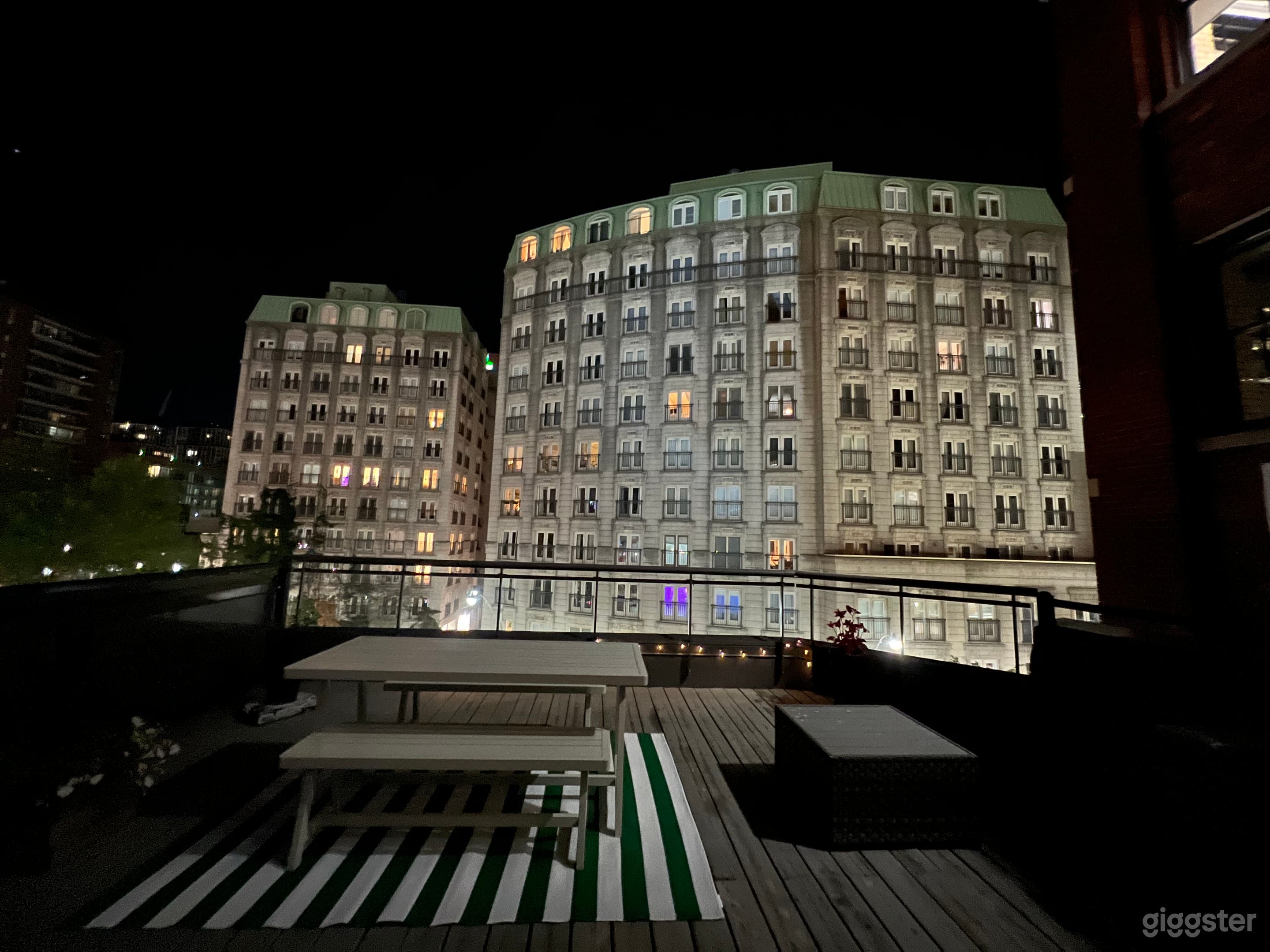 Large spacious rooftop at night with European style building backdrop in the heart of the city 