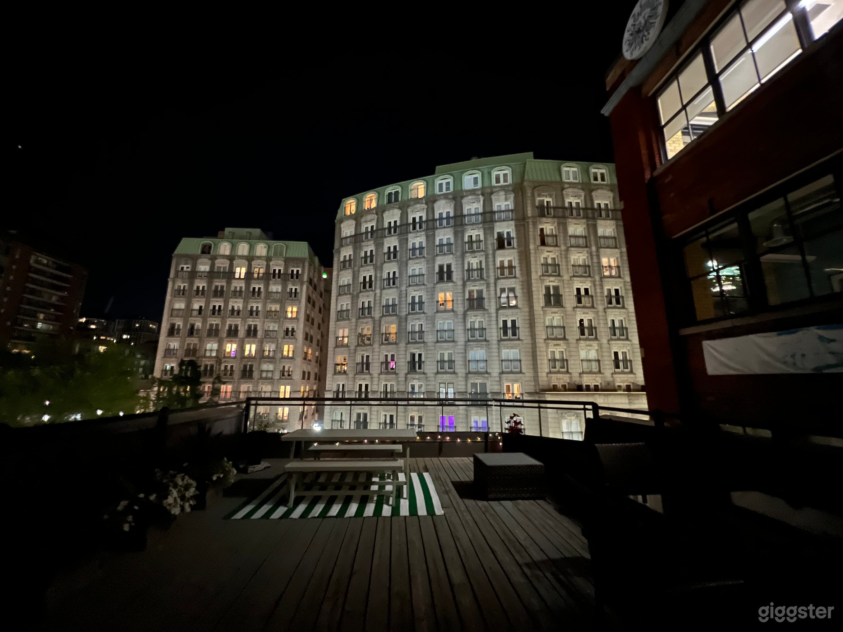 Large spacious rooftop at night with European style building backdrop in the heart of the city