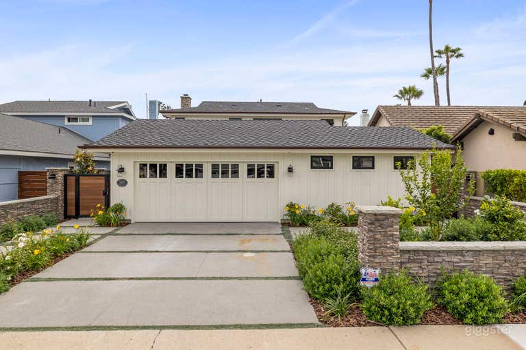  Front of house featuring concrete driveway with lush, well maintained landscaping.  