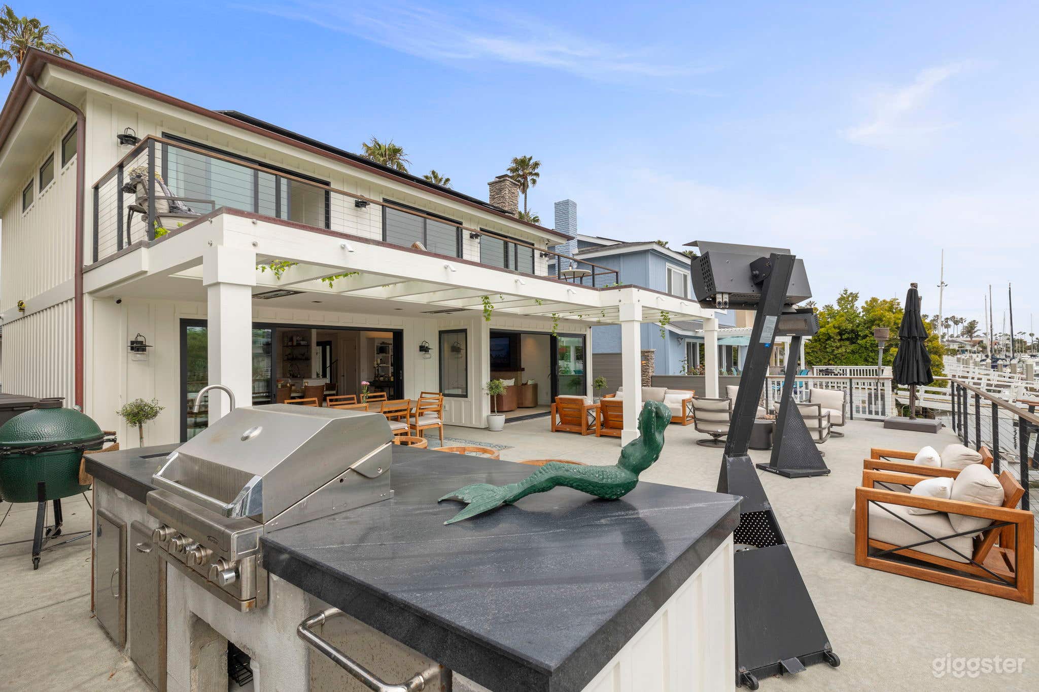 Back deck featuring BBQ and bar area, fire pit, with large sliding glass doors into kitchen and living room.