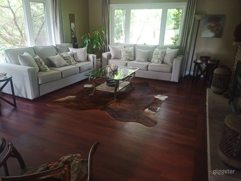  Living room with stone fireplace with views of the front and side gardens. 