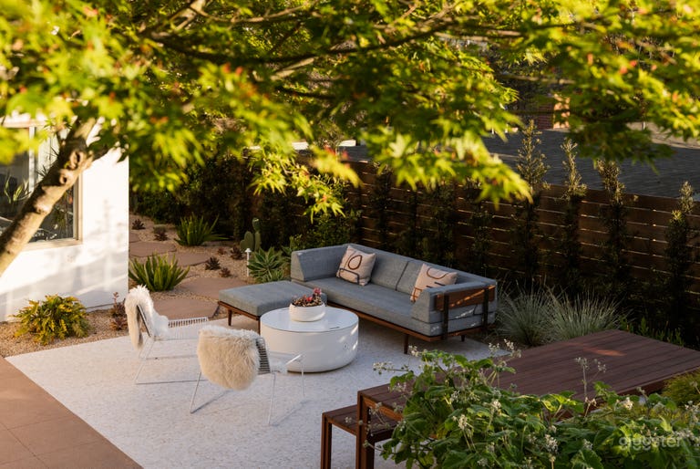  Ground floor of the patio featuring wooden Modernica table and sectional, as well as  the fire pit - with the lid on it acts as a coffee table 