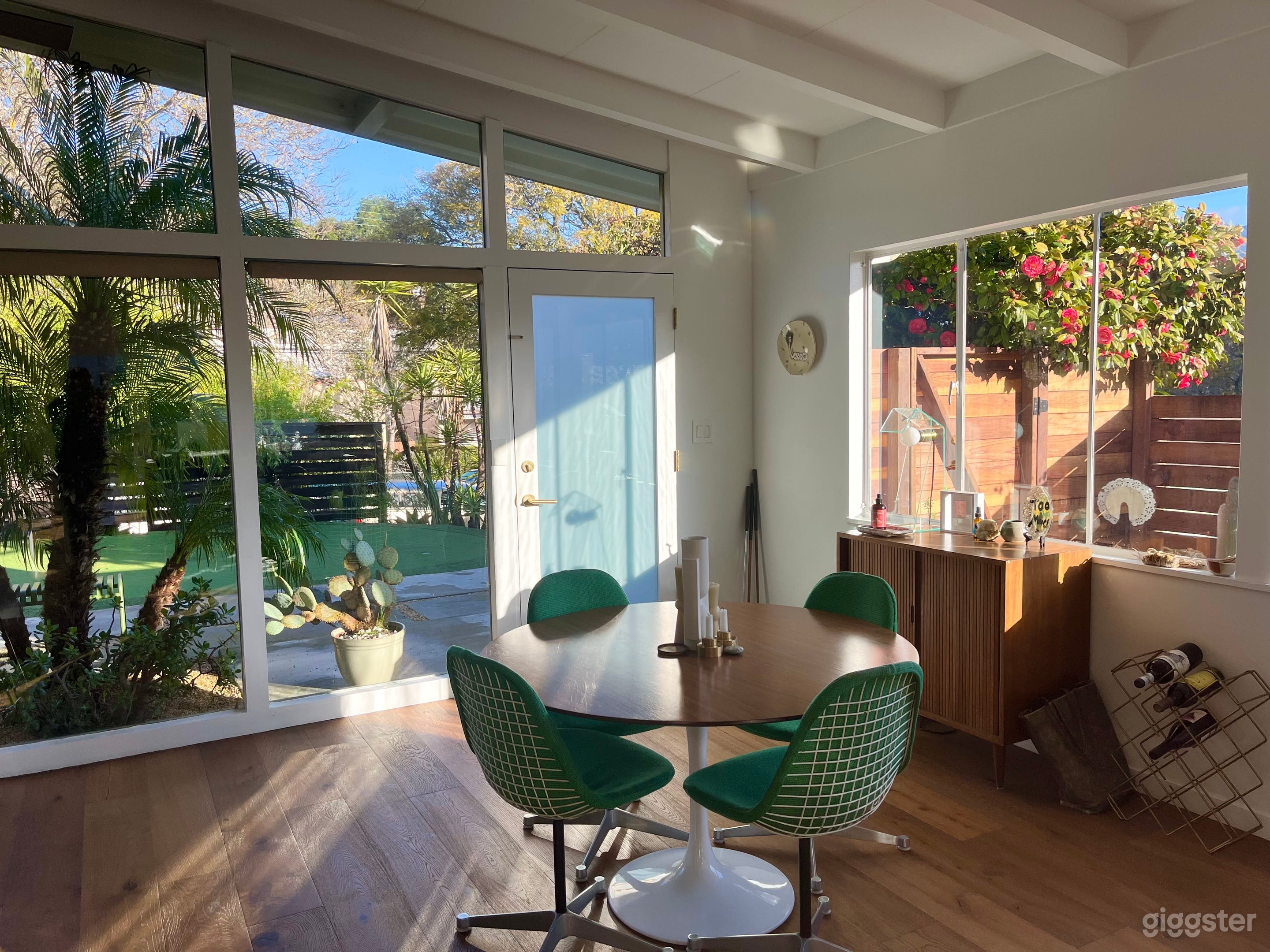 Dining area with original Herman Miller chairs and floor to ceiling windows overlooking the front yard